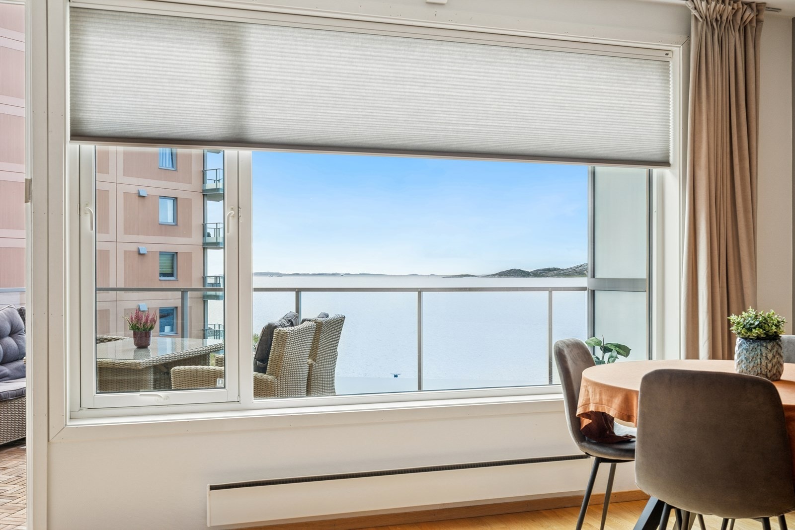 Upåklagelig utsikt over innseilingen mot Bodø havn med Hjartøya i bakgrunnen. Elektrisk solskjerm på vinduet. Galleribilde