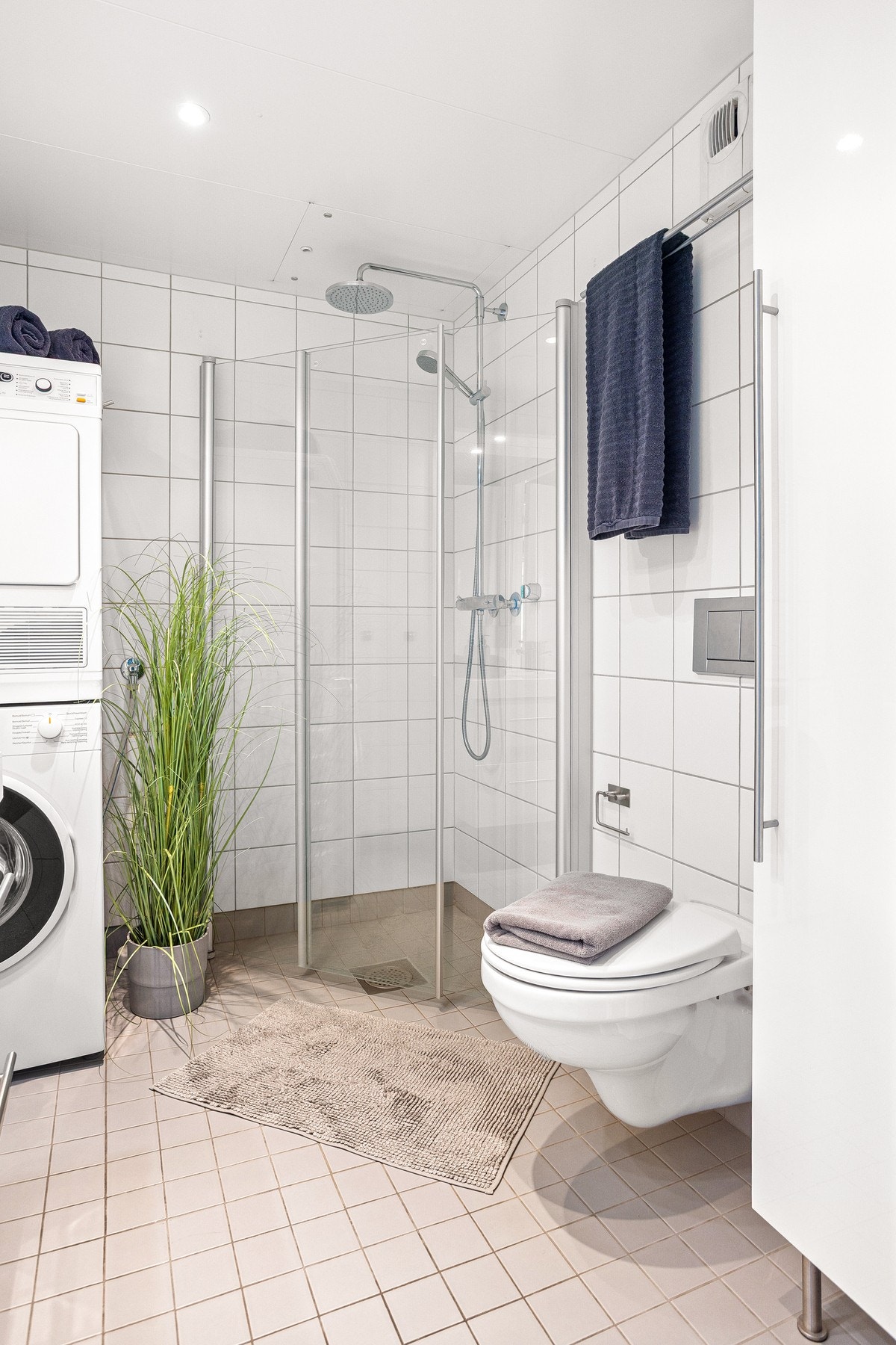 Dusjsonen er romslig, avskjermet med glassdører, og utstyrt med både regnfalldusj og to-greps armatur for optimal komfort. Badet har opplegg for både vaskemaskin og tørketrommel. Galleribilde