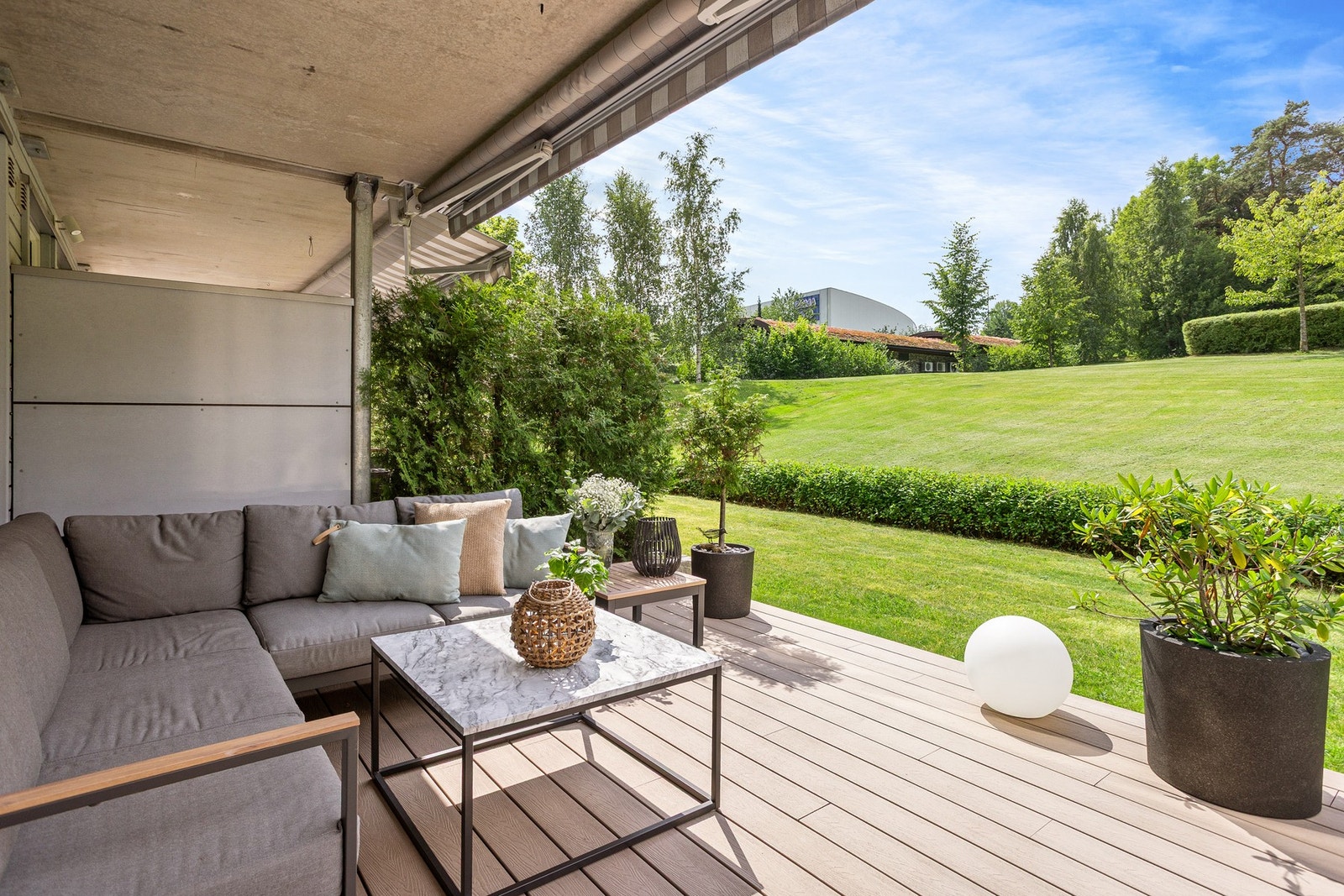 Terrassen ligger vendt ut mot et stort, grønt fellesområde, helt uten gjenboere, noe som gir en sjelden kombinasjon av både privatliv og romfølelse. Her får du en fredelig uteplass med flott utsyn og ingen innsyn - et ideelt sted å nyte sommerdager og lun Galleribilde