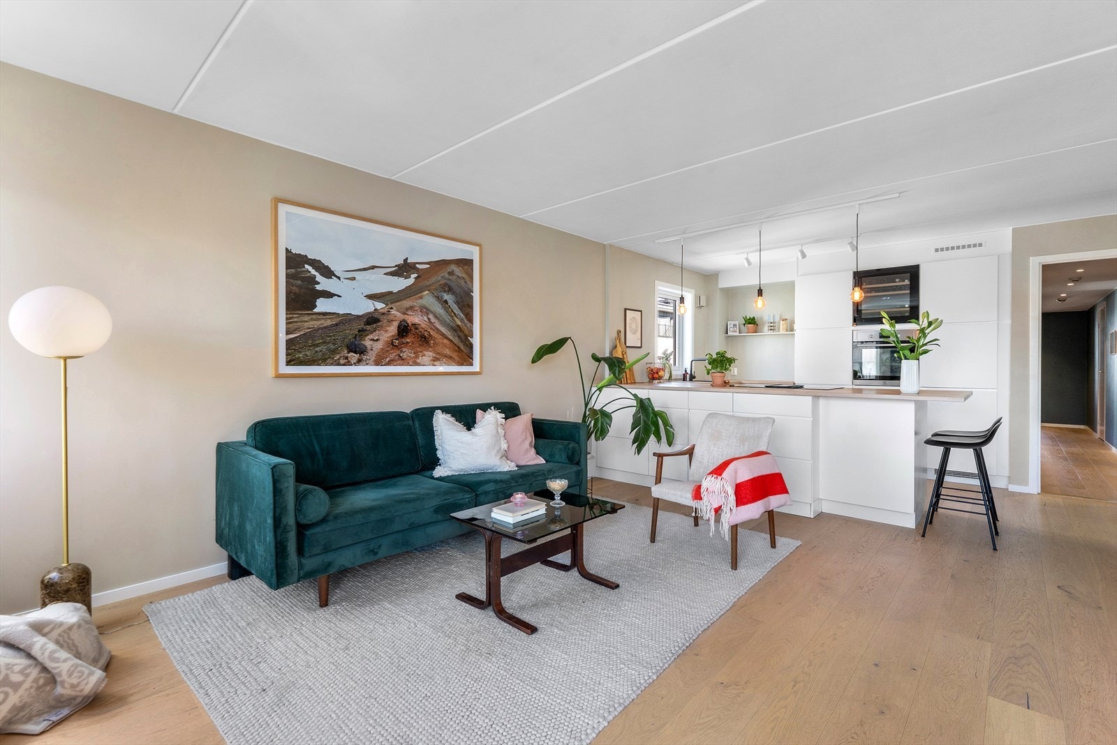 Stue- og kjøkken i åpen løsning som gir flere møbleringssoner Galleribilde