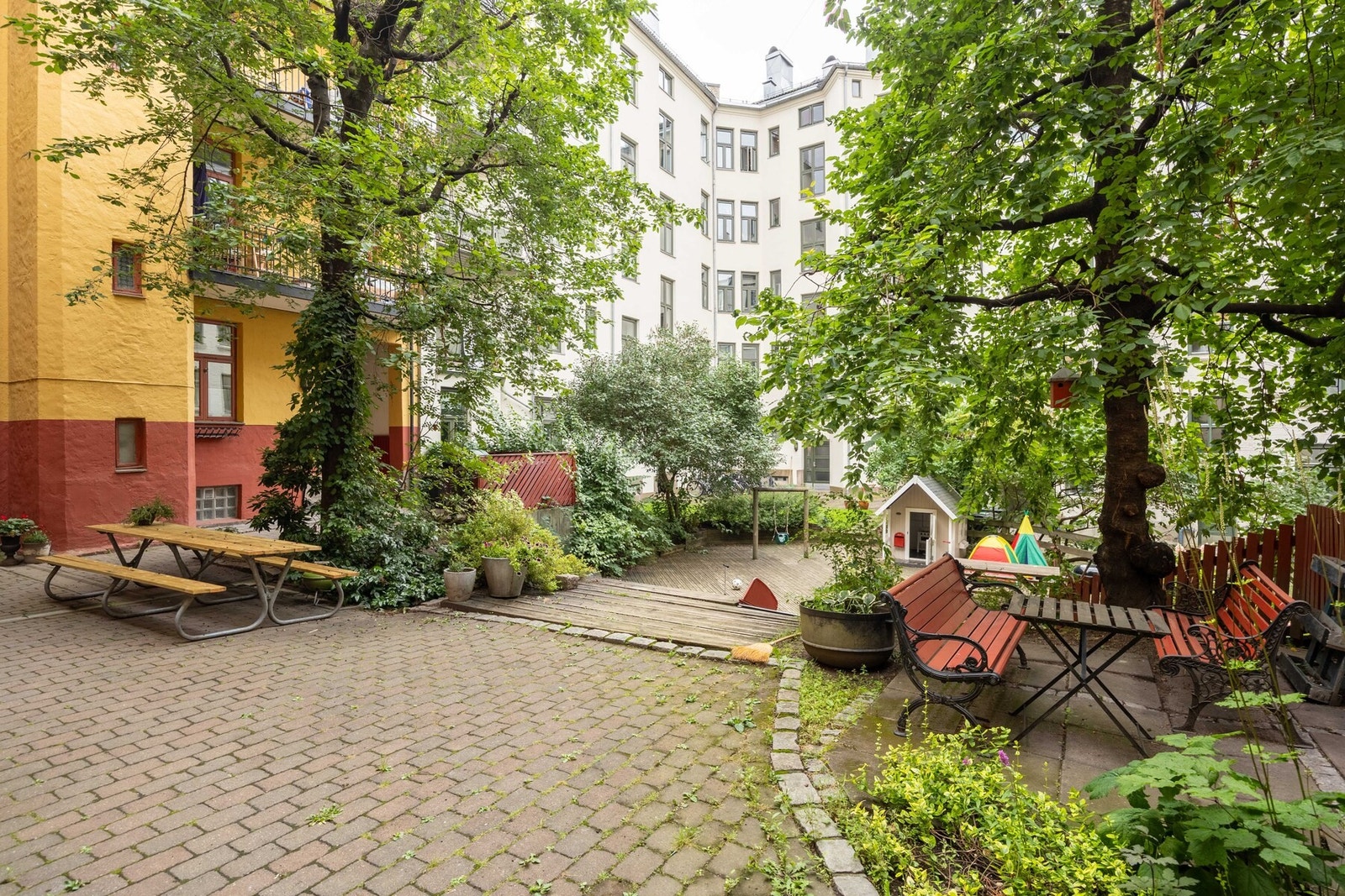 Veldrevet borettslag med pen bakgård opparbeidet med sittegrupper og sykkelparkering. Galleribilde