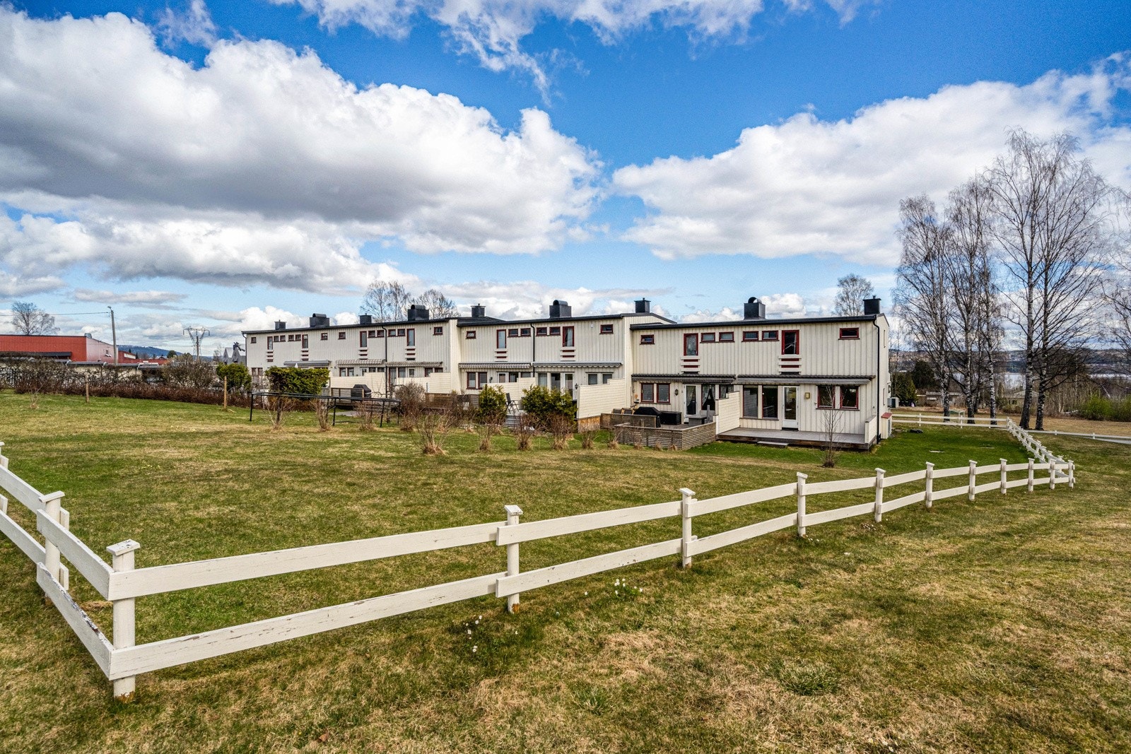 Eiendommen ligger på en felles tomt på hele 11 820 m², pent opparbeidet med plen, beplantning og lekeplass - et trygt og trivelig uteområde for både store og små. Galleribilde