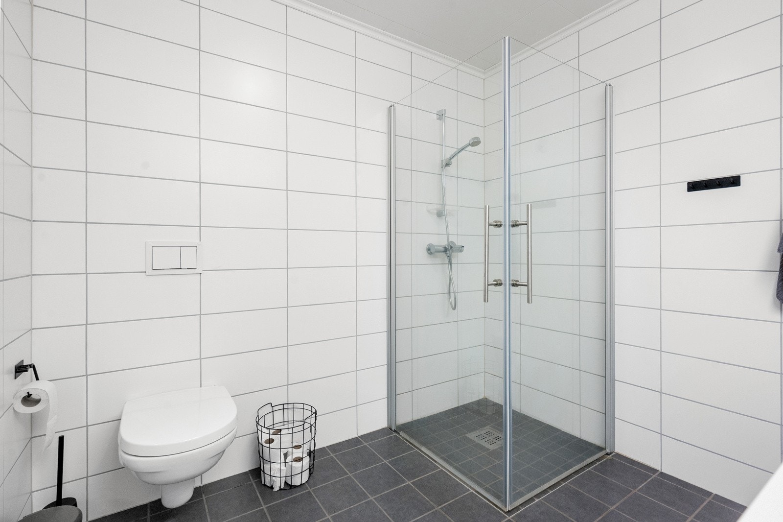 Badet er også utstyrt med dusjvegger og vegghengt wc Galleribilde