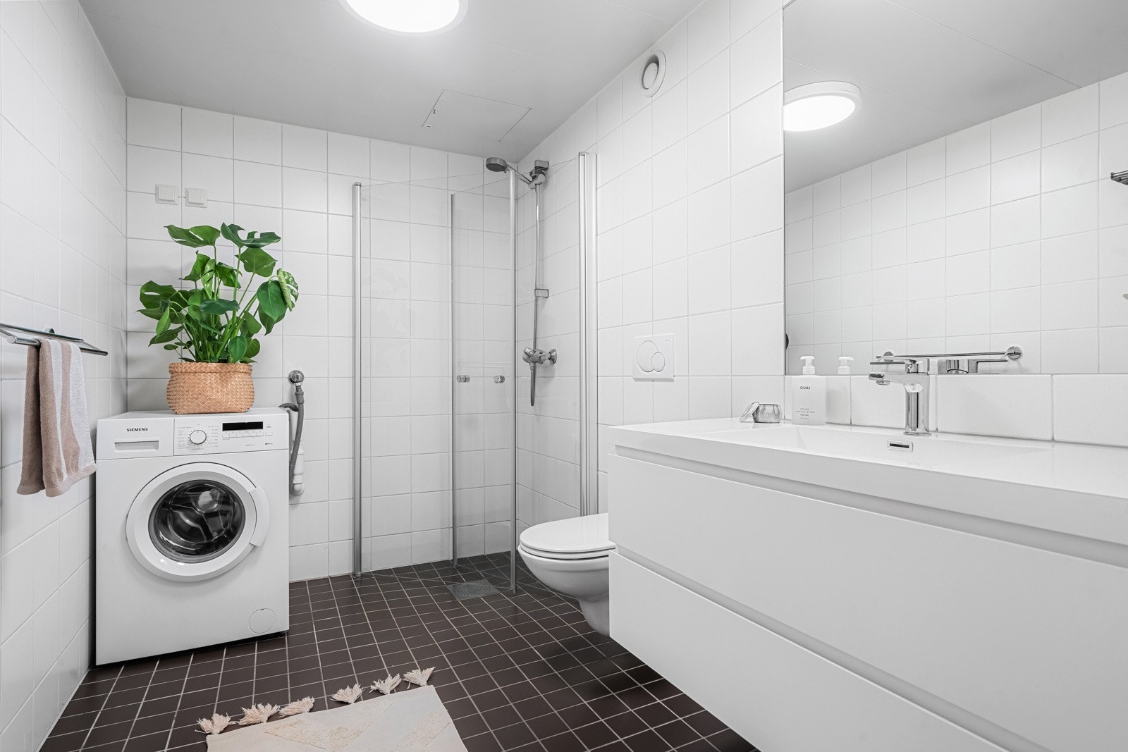 Lyst, lekkert og moderne baderom med opplegg for vaskemaskin og trommel Galleribilde