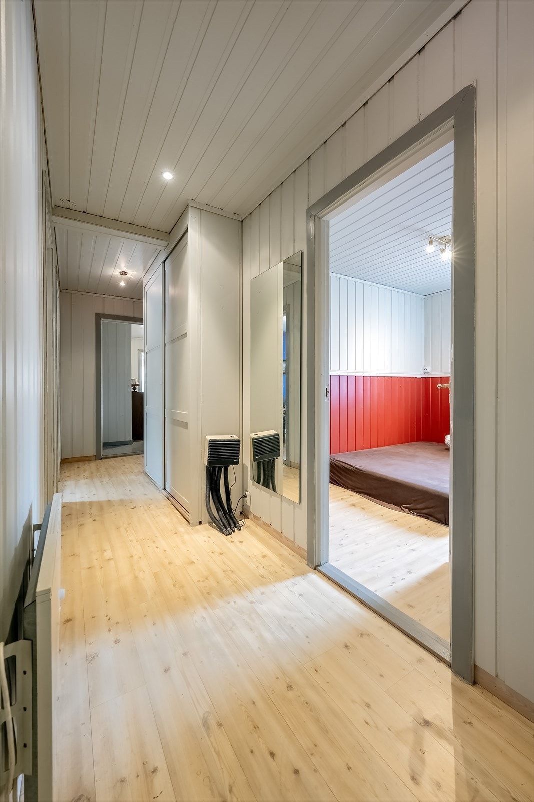 Gang med skyvedørsgarderobe og inngang til alle soverom samt en bod Galleribilde