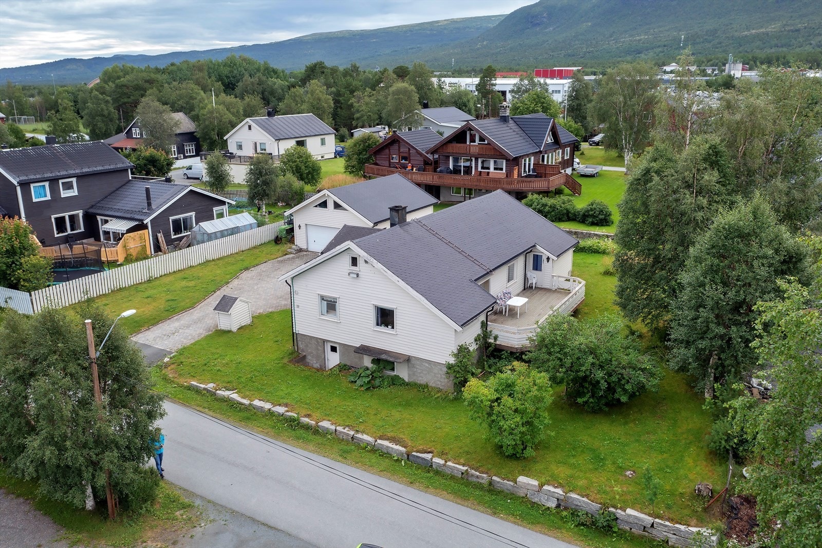 Tomtearealet er relativt flatt/lett hellende og opparbeidet med plen, beplantning, steinsatt gårdsplass samt støttemurer og terrasse i naturstein Galleribilde