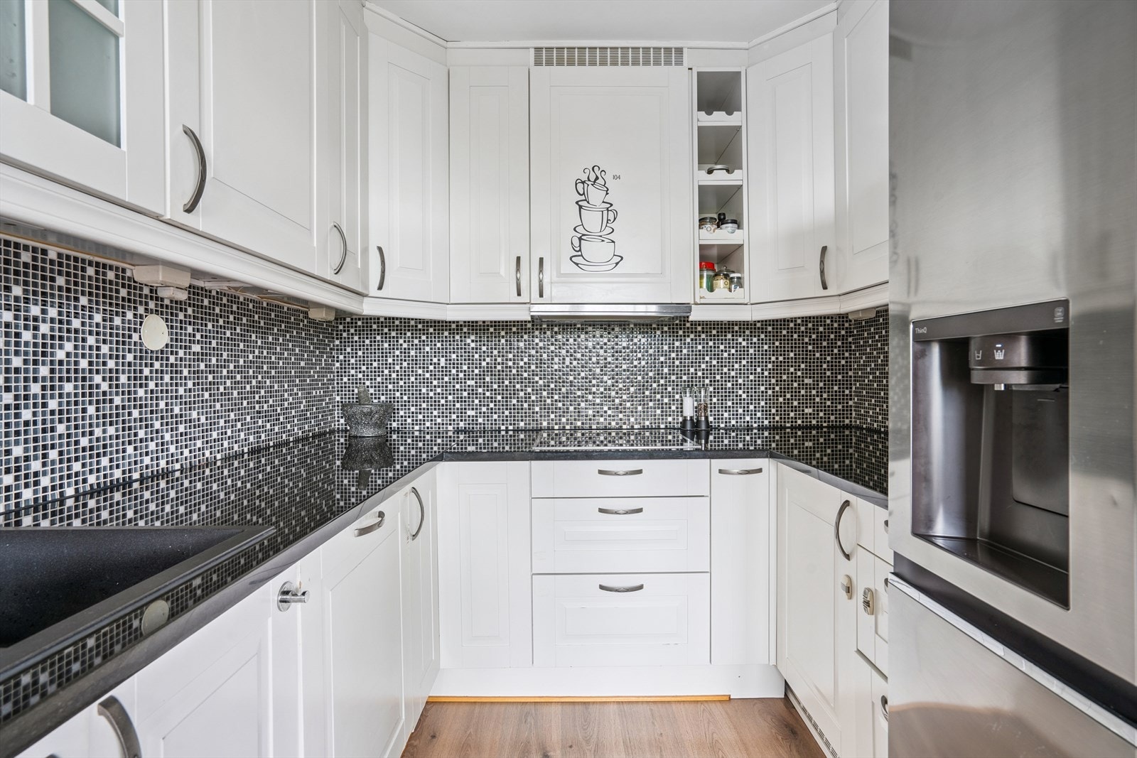 Kjøkken fra Kitchen2all. Innredningen har glatte fronter, og benkeplaten er laminert med nedfelt vask og platetopp. Galleribilde