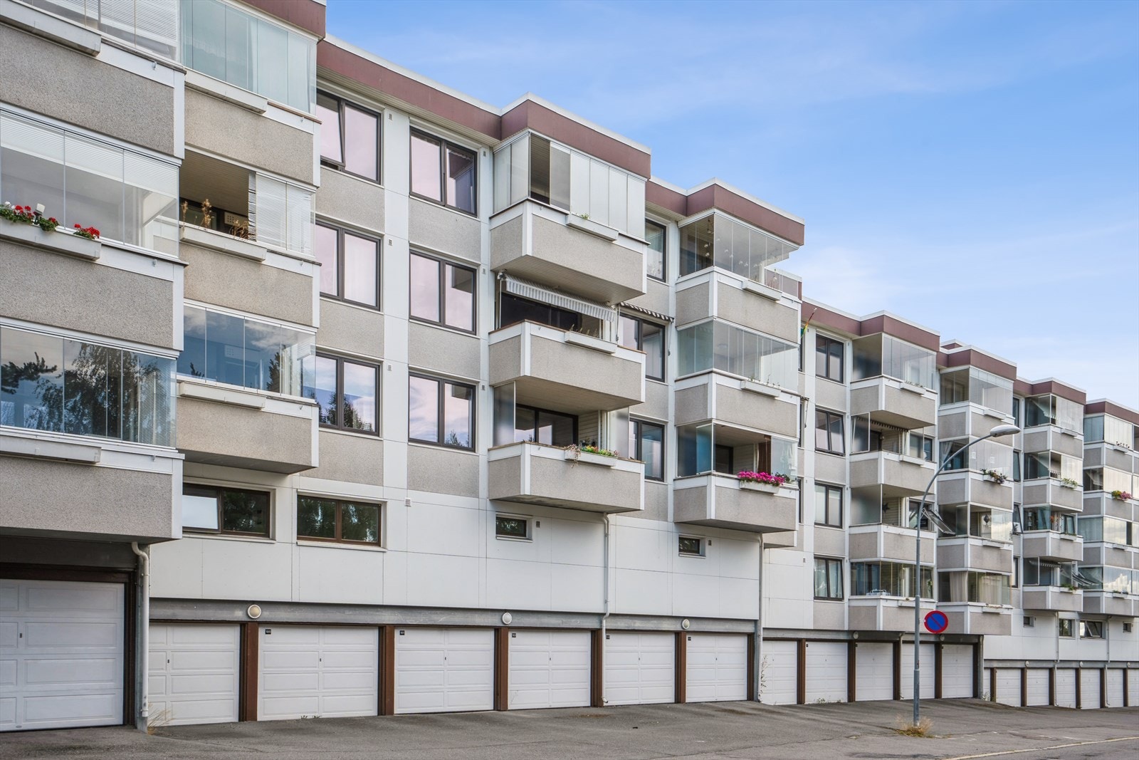 Fasade sett fra Sigrid Undsets vei. Her er det gratis, offentlig parkering langs veien. Borettslaget har også 120 garasjer og 324 parkeringsplasser som leies ut til beboerne. Galleribilde