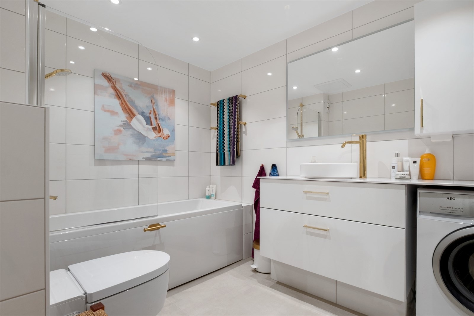 Badet ble totalrenovert i 2024 og fremstår som både ubrukt og moderne. Det romslige badet er innredet med badekar/dusj, vegghengt toalett, servant og opplegg for vaskemaskin Galleribilde