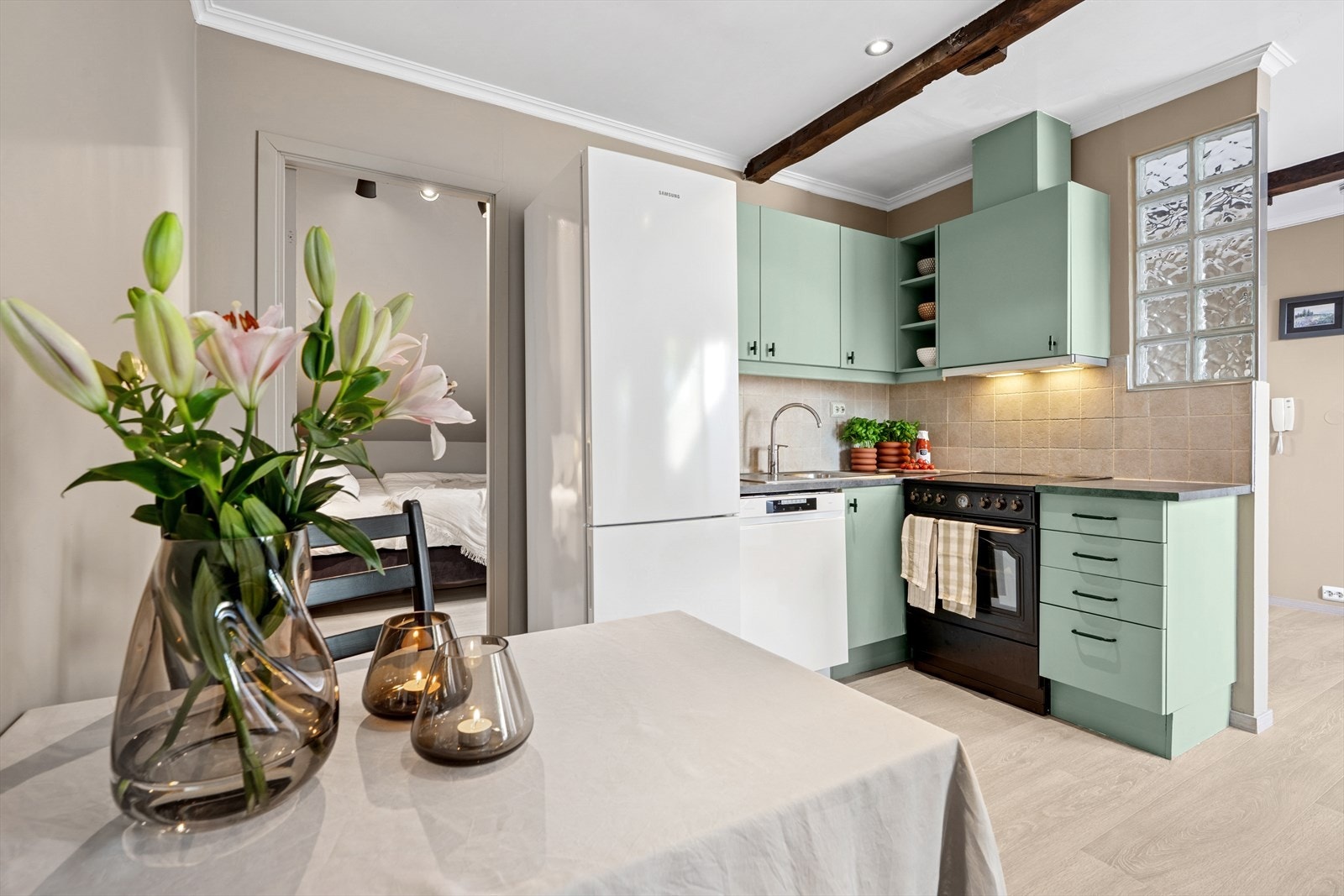 Kjøkkenet er innredet med mekanisk vifte over komfyr, lyslist under overskap, laminert benkeplate, kum og blandebatteri, samt opplegg for oppvaskmaskin. Galleribilde