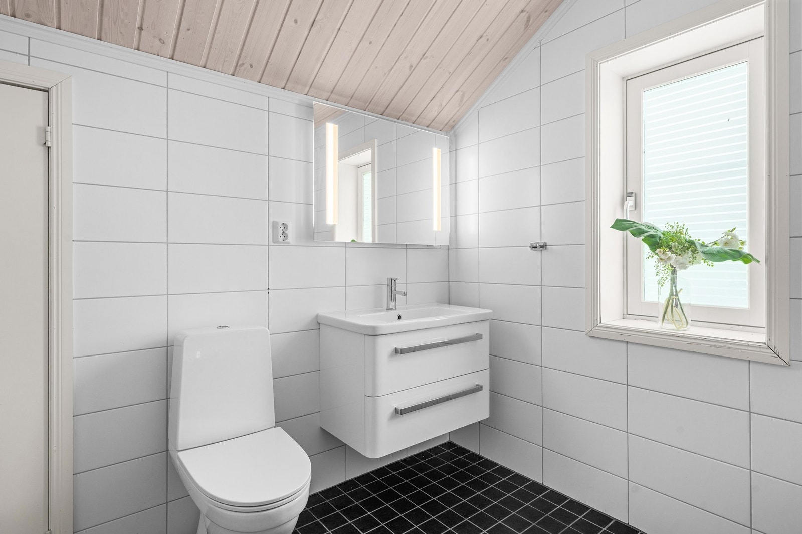 Badet er innredet med flislagte gulv- og veggflater, samt panel i himlingen Galleribilde