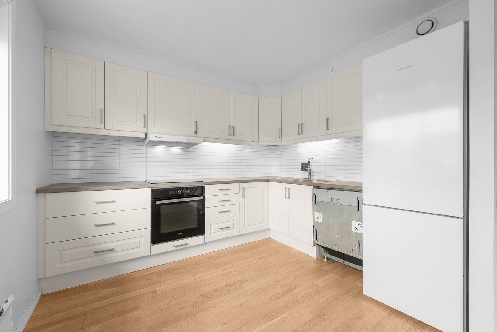 Mellom benk og overskap er det montert Trespo/Fibo-plater, og under overskapene er det praktisk belysning. Kjøkkenet har avtrekk tilknyttet boligens mekaniske avtrekksanlegg Galleribilde