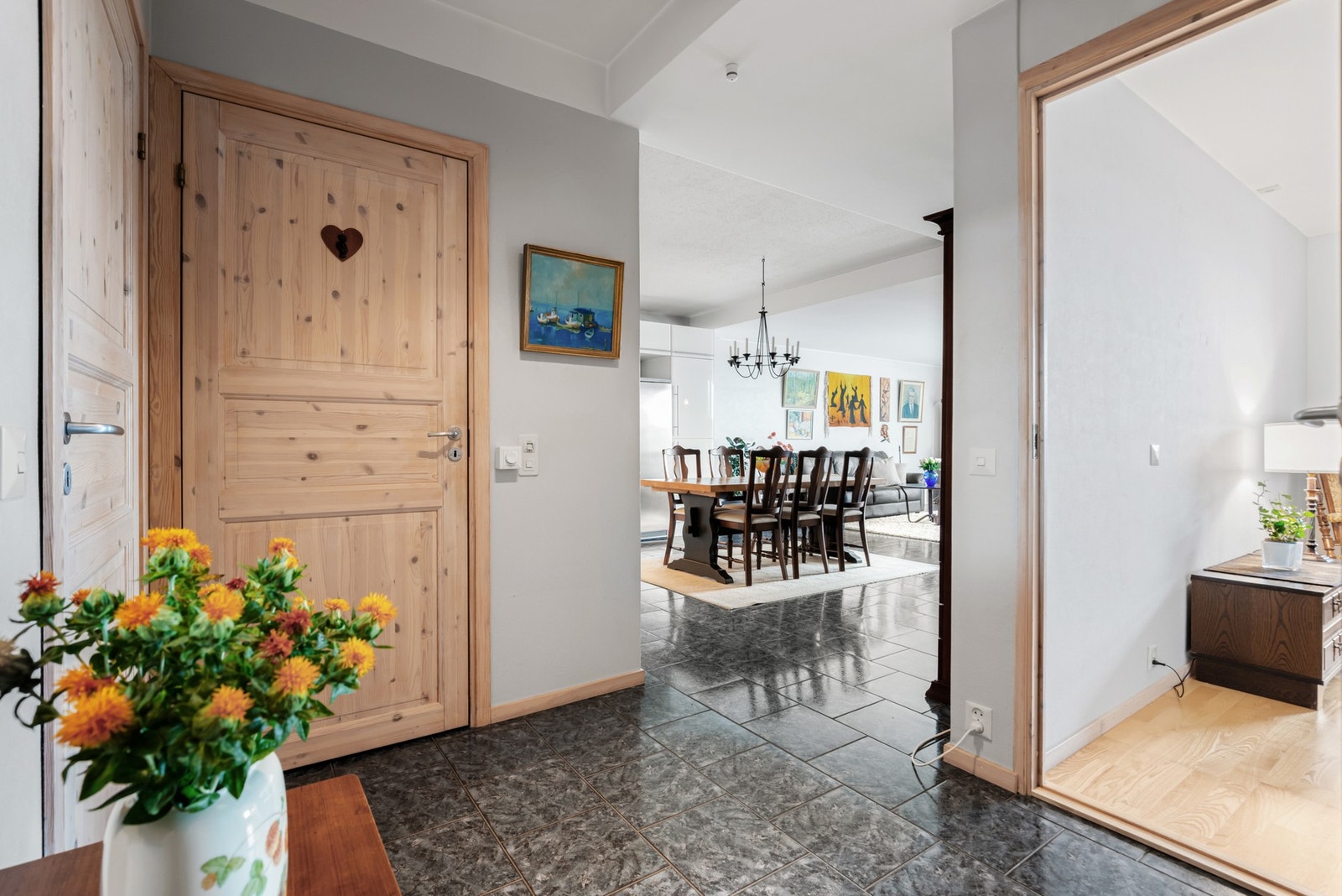 Leiligheten har lysmalte vegger og blanke fliser på gulvet - en stilkombinasjon som fortsetter inn i gang, kjøkken og stue. Galleribilde