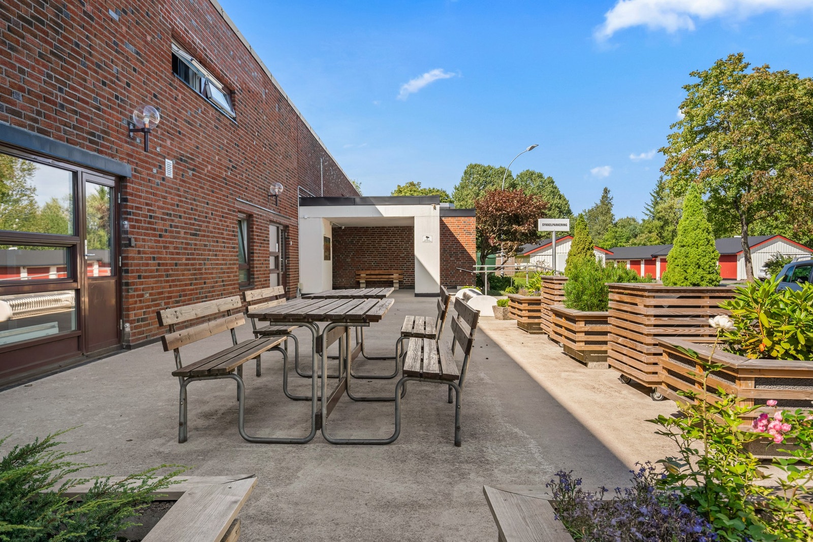 På fremsiden av bygget er det også en pent opparbeidet sitteplass til felles anvendelse. På denne siden er det morgensol. Galleribilde