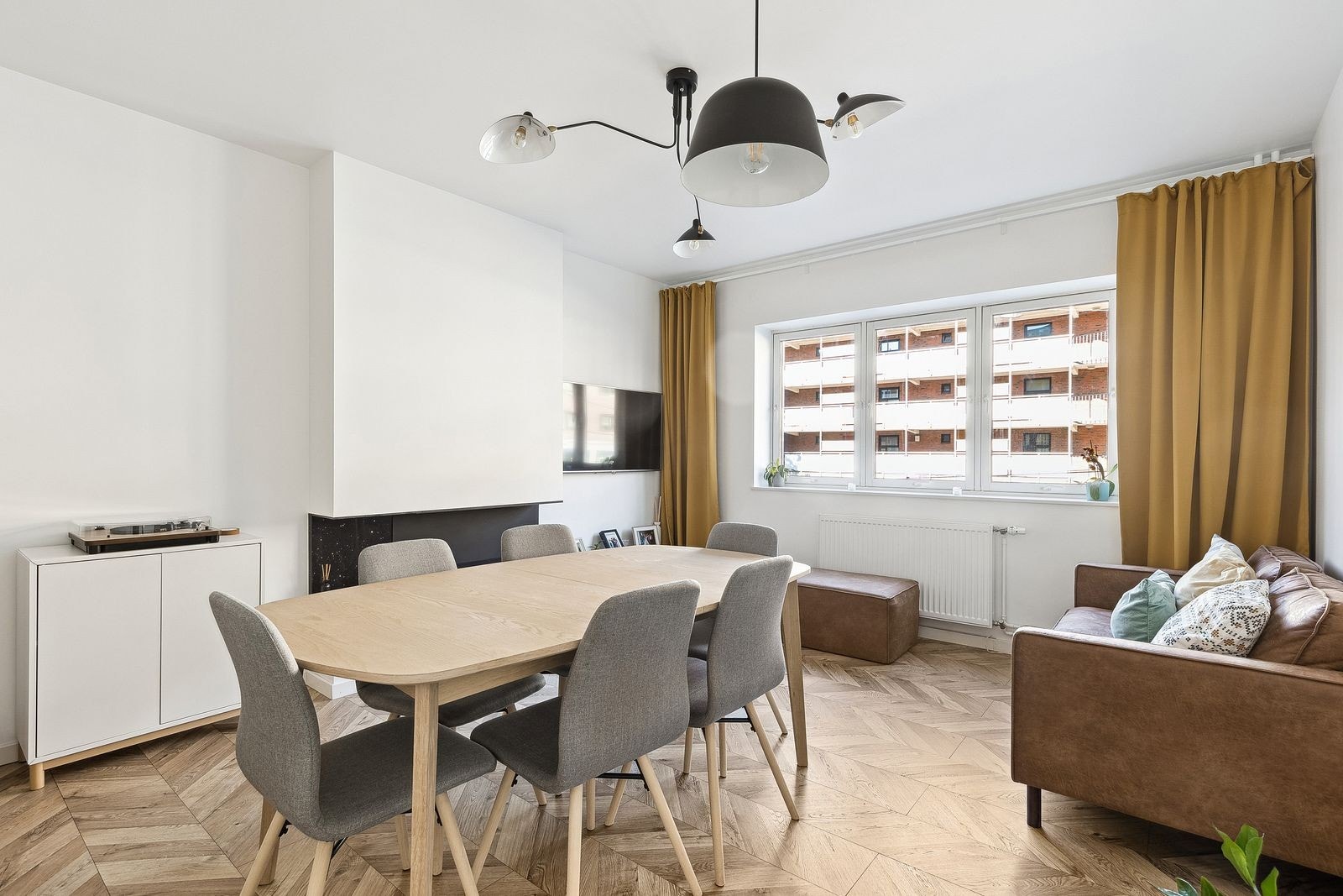 Lys og innbydende stue med store vindusflater og biopeis. God plass til både sofa og spisebord. Galleribilde