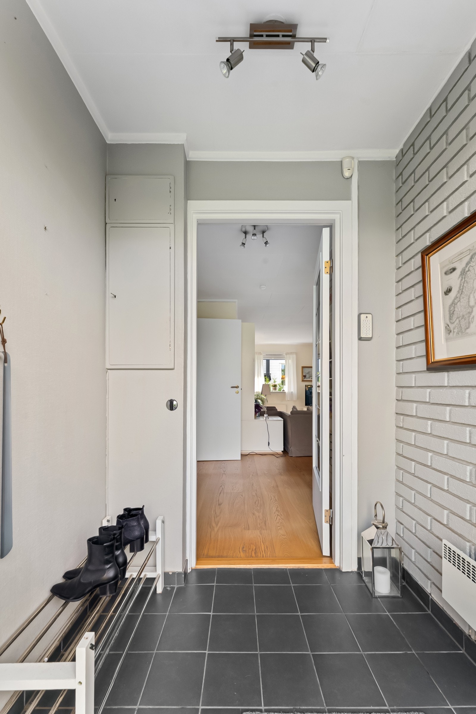 Flislagt entré med plass til å henge fra seg yttertøy og sette fra seg sko. Galleribilde