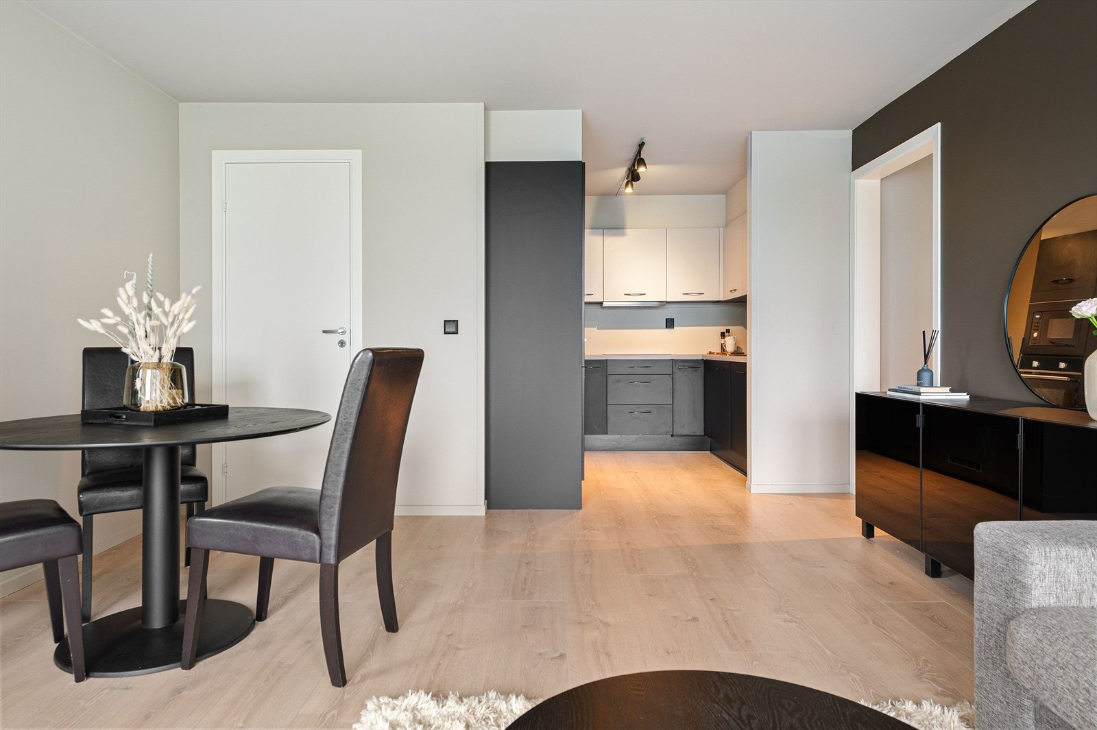 Leiligheten har glatte overflater i tidsriktige farger, nyere laminatgulv og en naturlig soneinndeling med møbler. Galleribilde