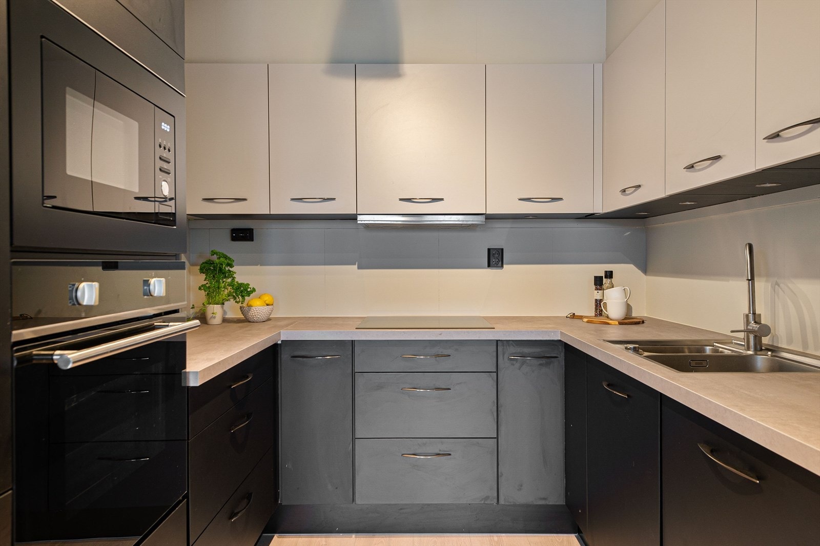 Det er benkeplate i laminat, godt med strømuttak og lys under overskap. Galleribilde