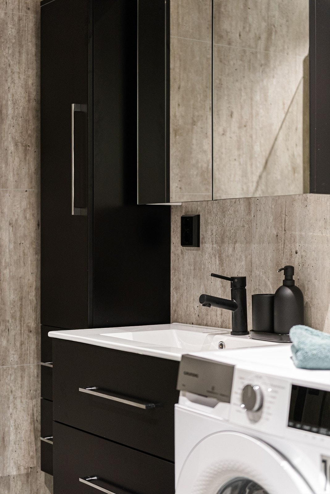 Badet har gulvvarme, opplegg for vask/tørk og stilren sort innredning med mye lagringsplass. Galleribilde