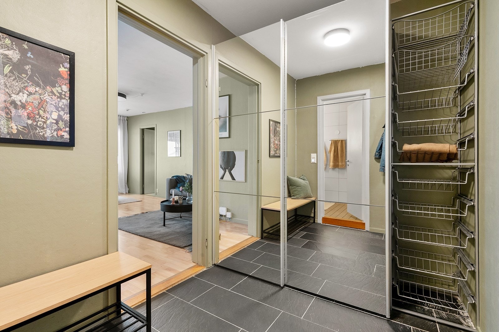 Romslig entré med plass til å henge fra seg yttertøy i stor skyvedørsgarderobe. Det er heisadkomst til leilighetsplan Galleribilde