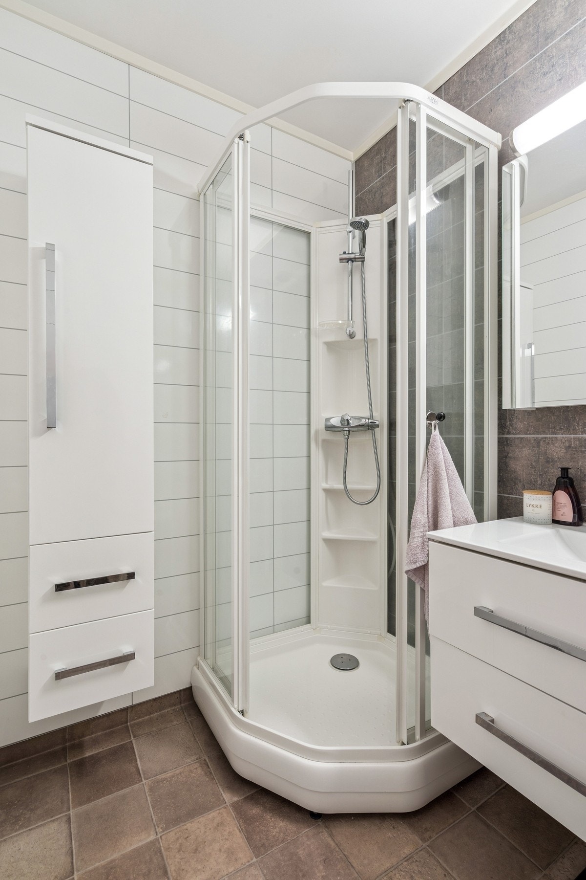 Rommet er innredet med toalett, servant på skuffeseksjon, høyskap og dusjkabinett. Galleribilde