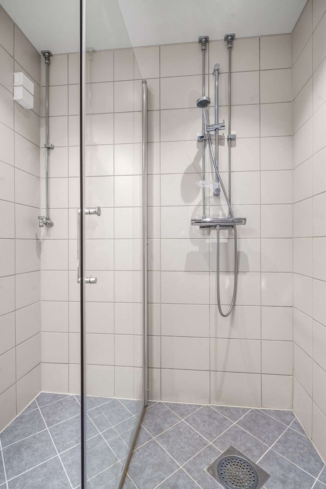 Baderommet er innredet med servantinnredning, dusjvegger/hjørne og opplegg for vaskemaskin. Galleribilde