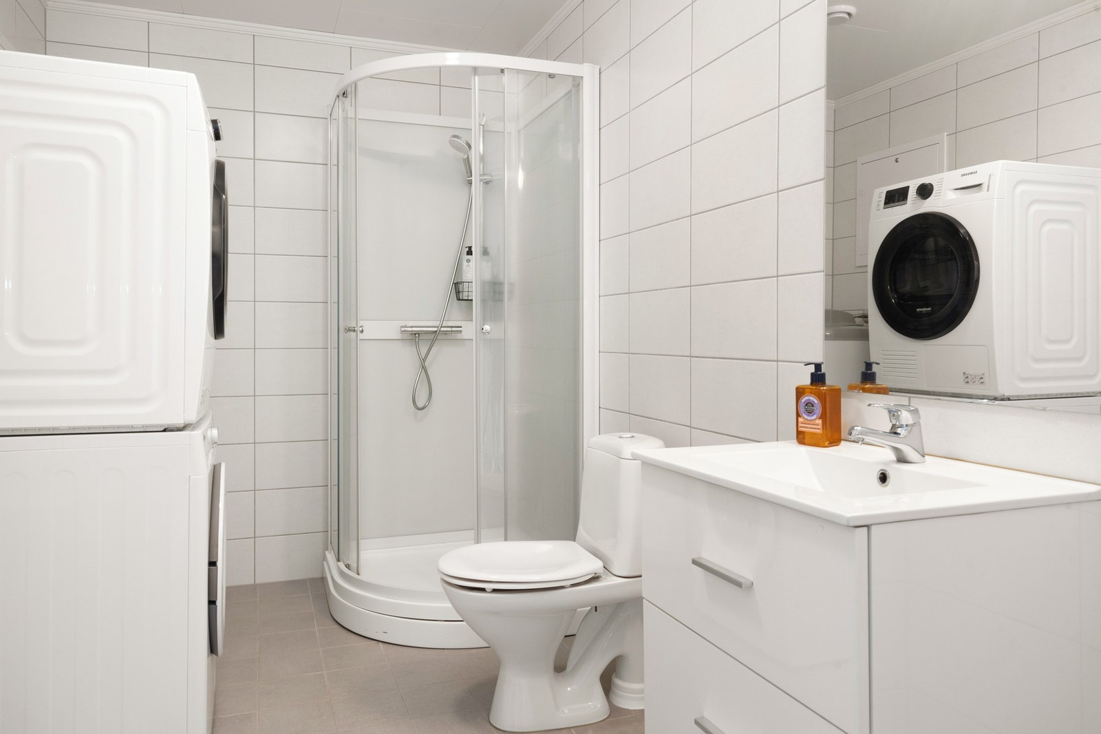 Boligen har et delikat flislagt bad innredet med nedfelt servant, speil med belysning, wc, dusjhjørne og opplegg for vaskemaskin/tørketrommel Galleribilde