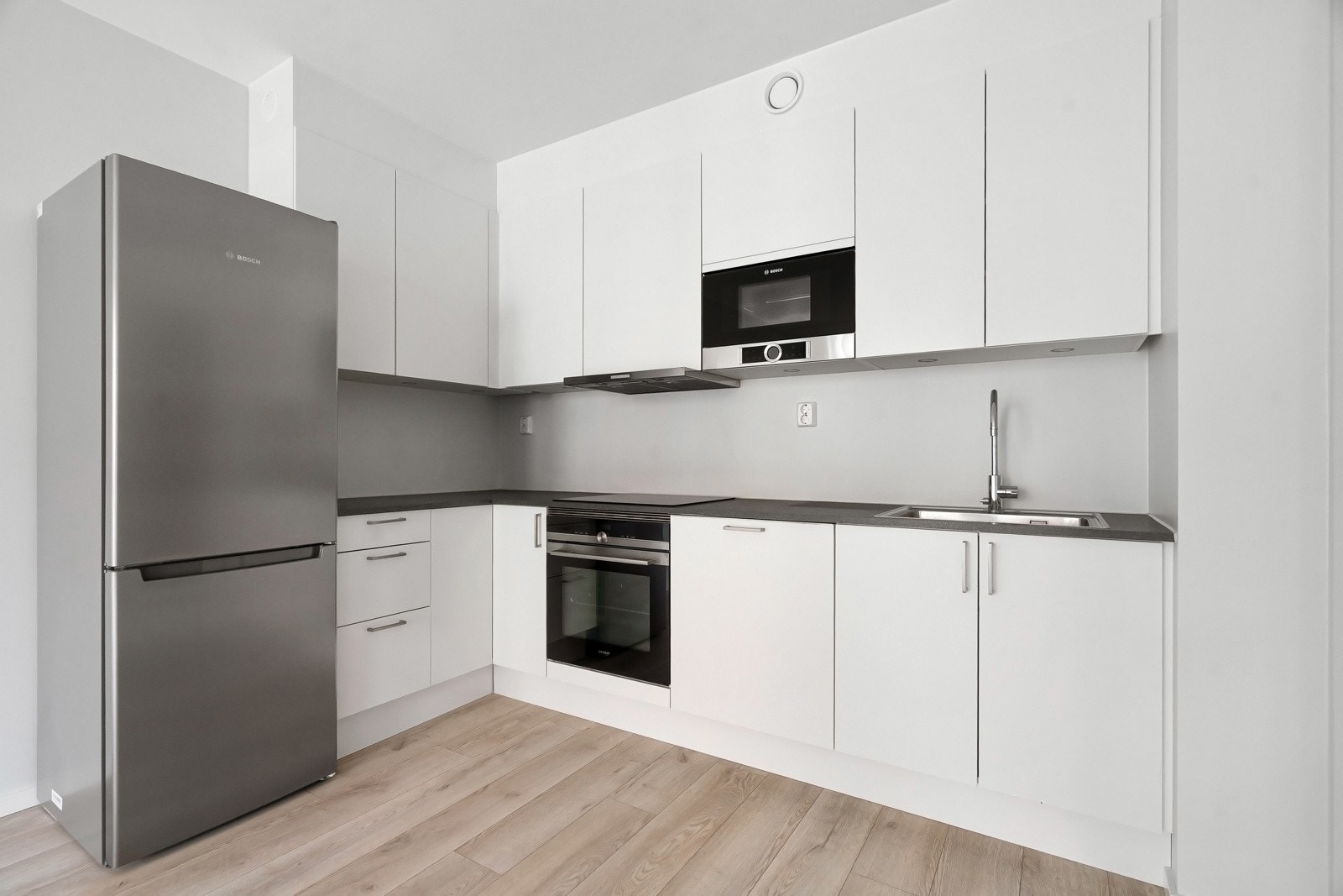 Kjøkkenet er utstyrt med oppvaskmaskin, induksjonstopp, micro, stekeovn og komfyrvakt. Plass til frittstående kjøleskap. Galleribilde