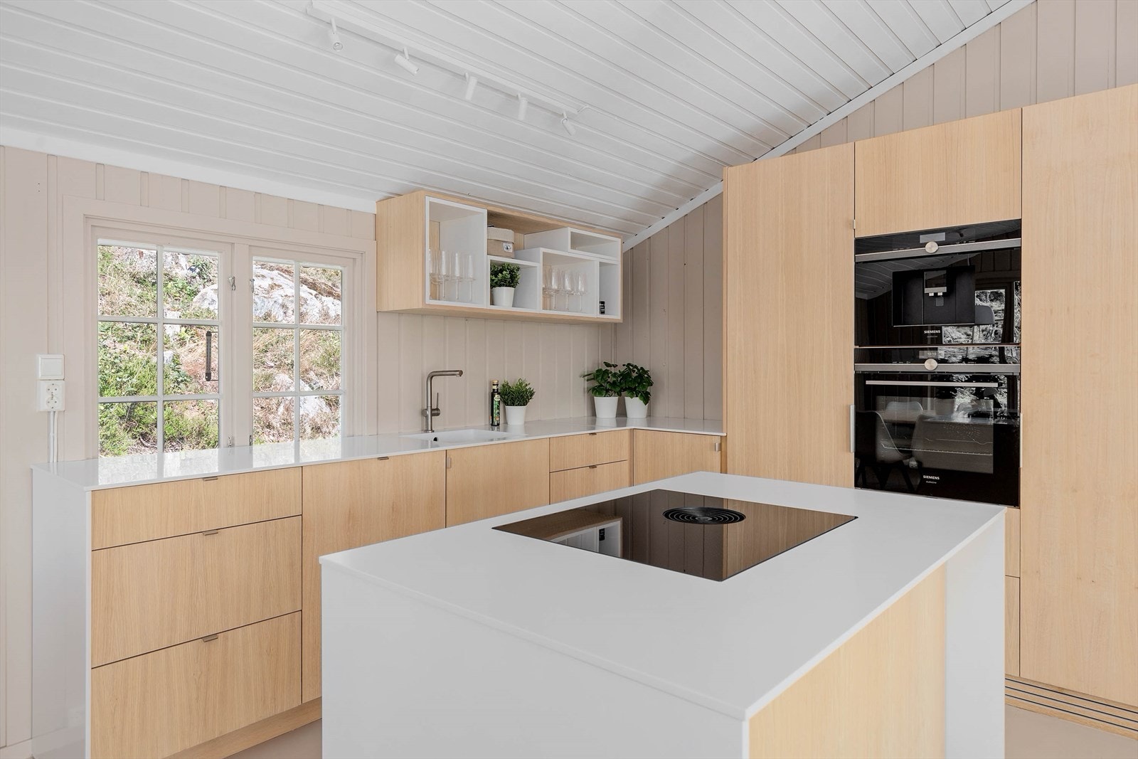 Høykvalitets møbelsnekret kjøkken i eik heltre og finér. Siemens hvitevarer og Bora ventilator. Corian benkeplate. Galleribilde