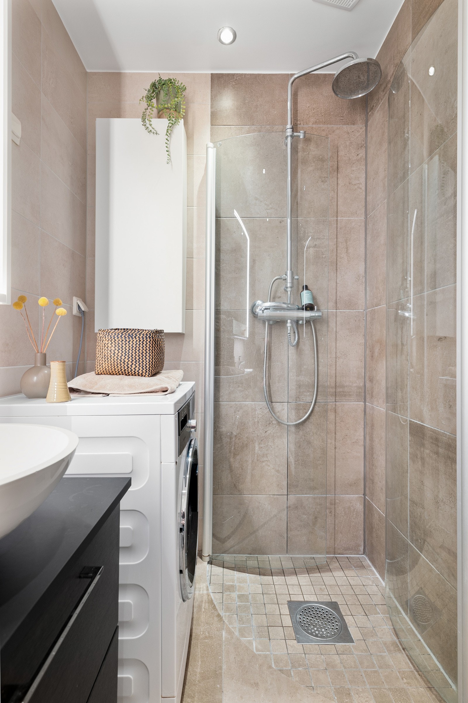 Badet inneholder vegghengt innredning med skuffer og ovenpåliggende servant, speilskap med belysning, gulvmontert toalett og dusjhjørne med regnfallsdusj og innfellbare dører i glass. Galleribilde