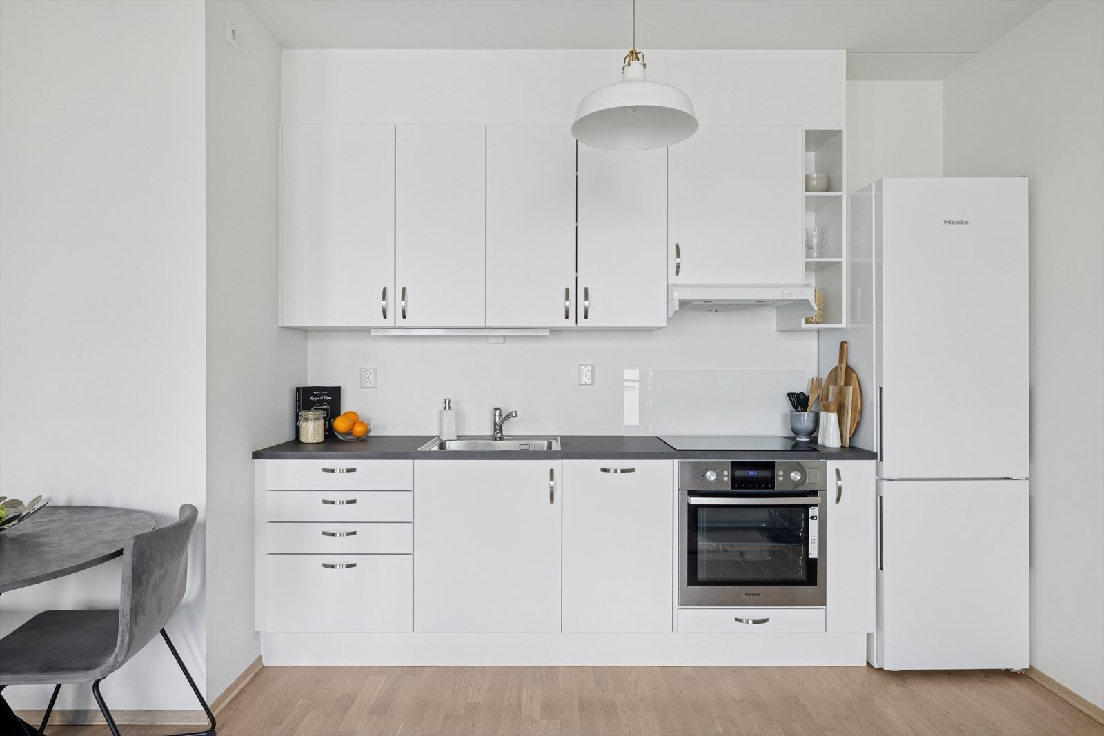 Kjøkkenet er utstyrt med integrerte hvitevarer som komfyr, platetopp og oppvaskmaskin- samt et frittstående kjøleskap med fryser Galleribilde