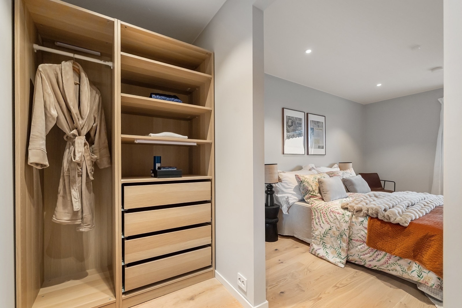 Praktisk walk-in closet med lekker innredning i to åpne skap med både skuffer, hyller og oppheng Galleribilde