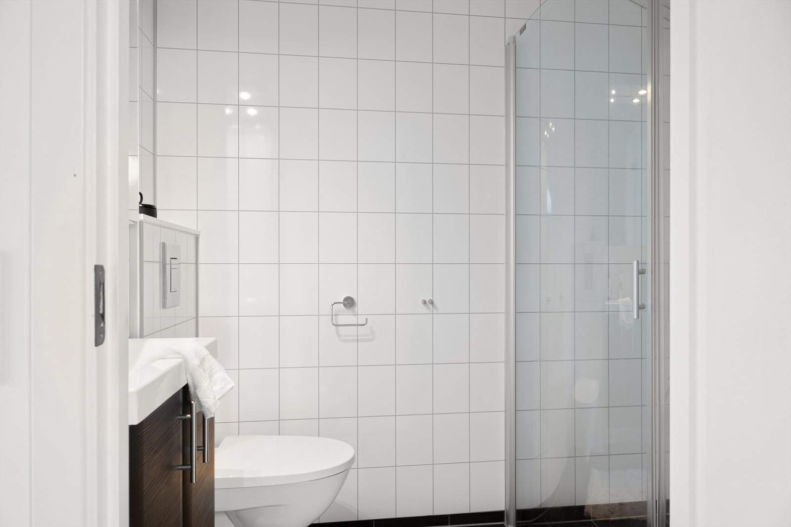 Bad med gulvvarme, downlights, dusjhjørne, servant i seksjon og vegghengt toalett. Galleribilde