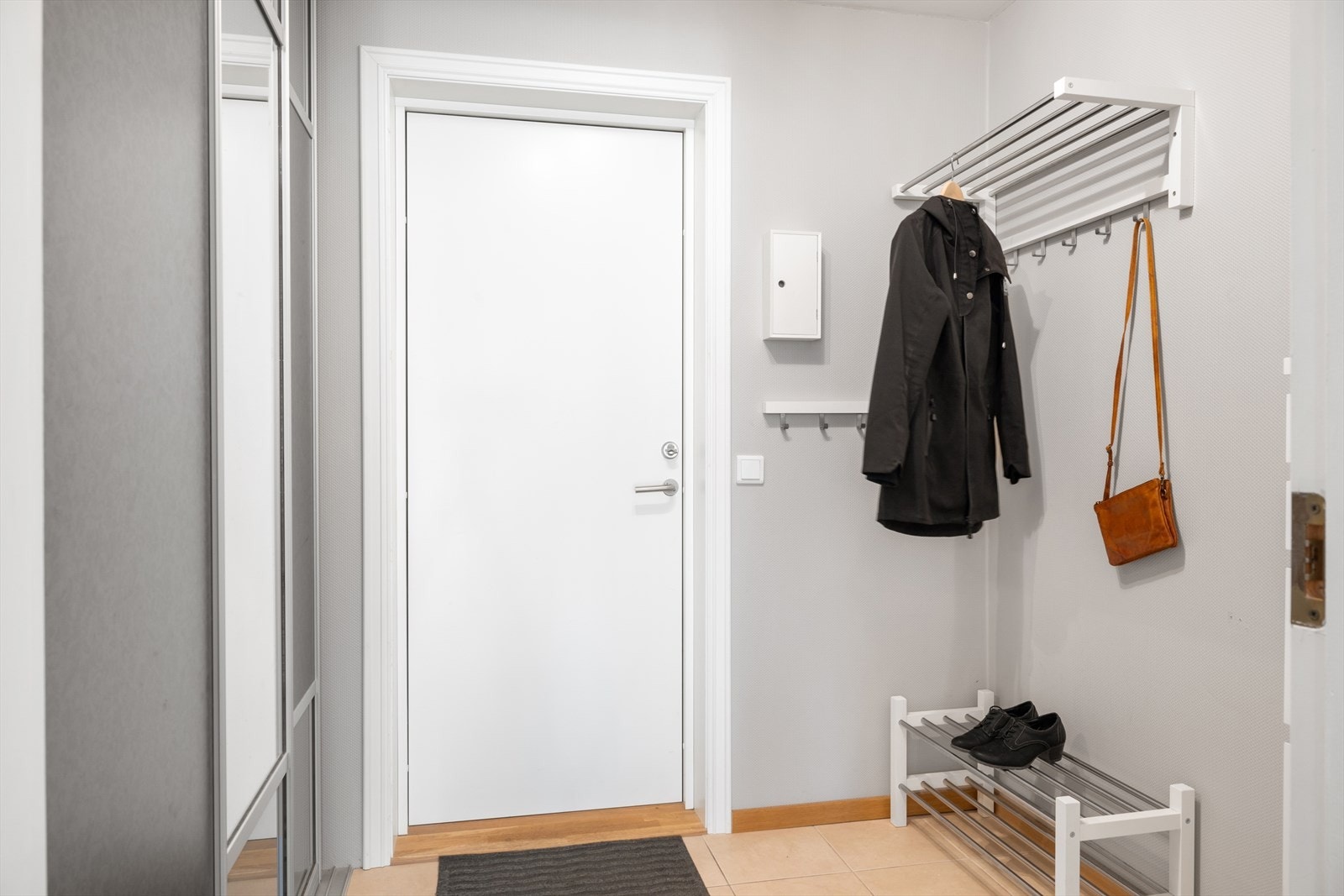 En lys og innbydende entré med praktisk skyvedørsgarderobe og god plass til oppbevaring av yttertøy. Galleribilde