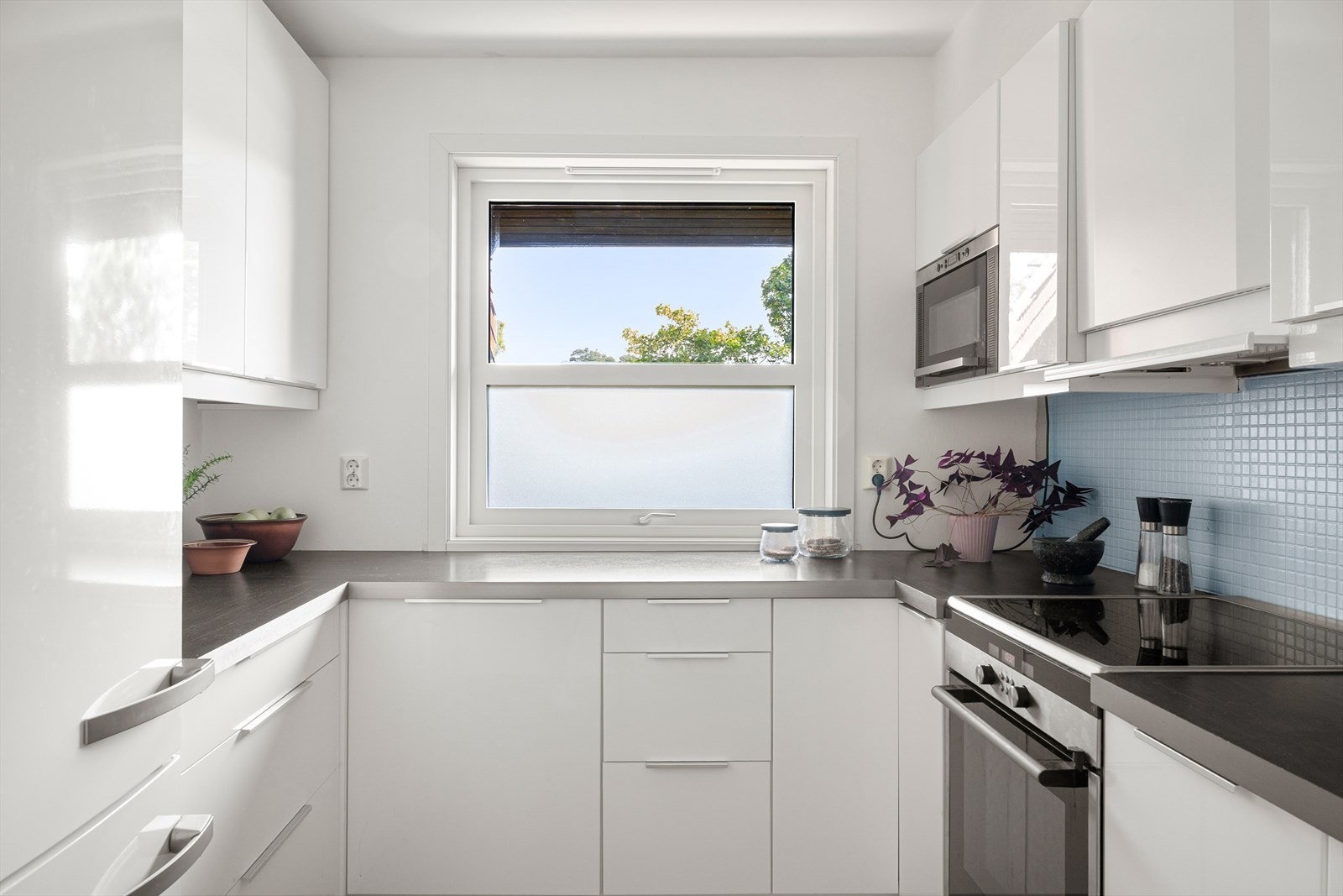 Kjøkkenet ligger adskilt fra stuen og har en funksjonell layout med hvite fronter og benkeplate i laminat. Galleribilde