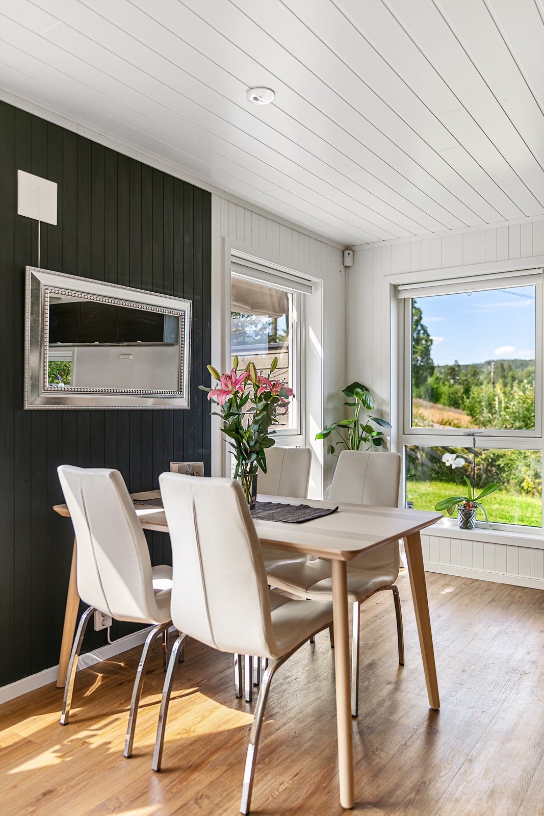 Spisestue det er høye vinduer i hele stue delen som gjør at de slipper inn masse lys. Galleribilde