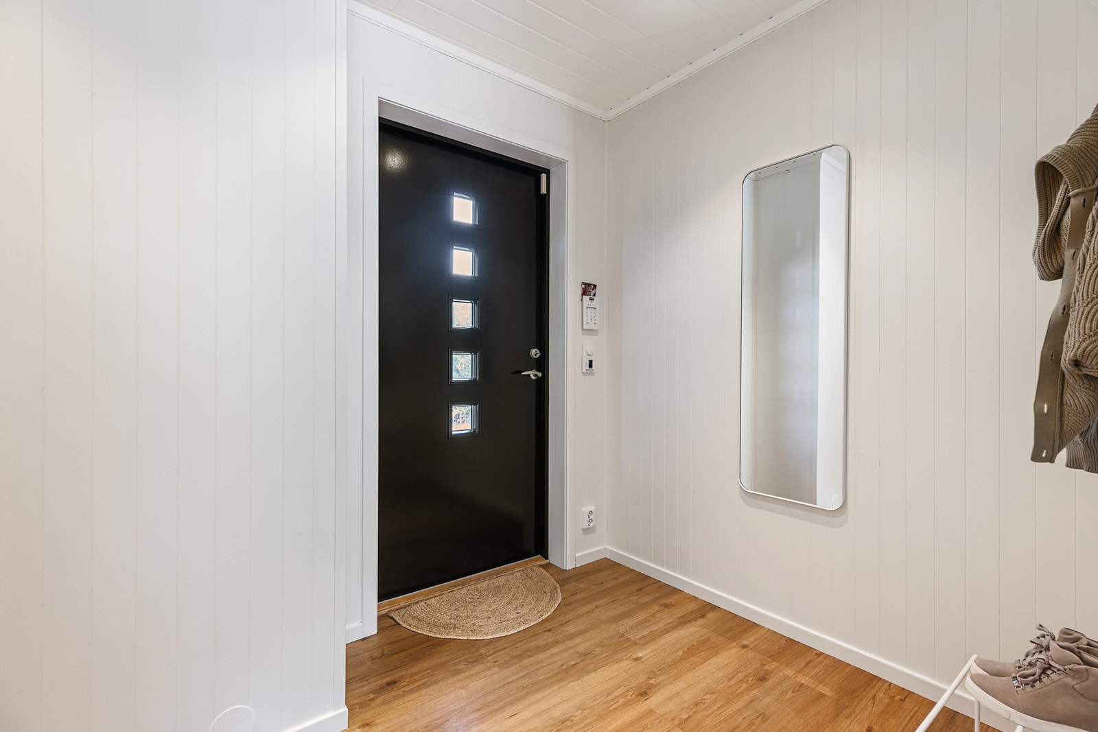 Stor luftig gang med parkett på gulv og hvite glatte vegger. Galleribilde