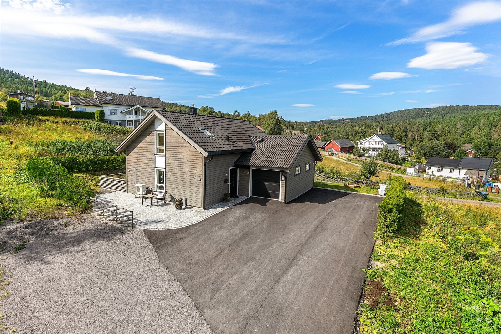 Stor asfaltert gårdsplass. Sitteplass med belegningsstein. Galleribilde