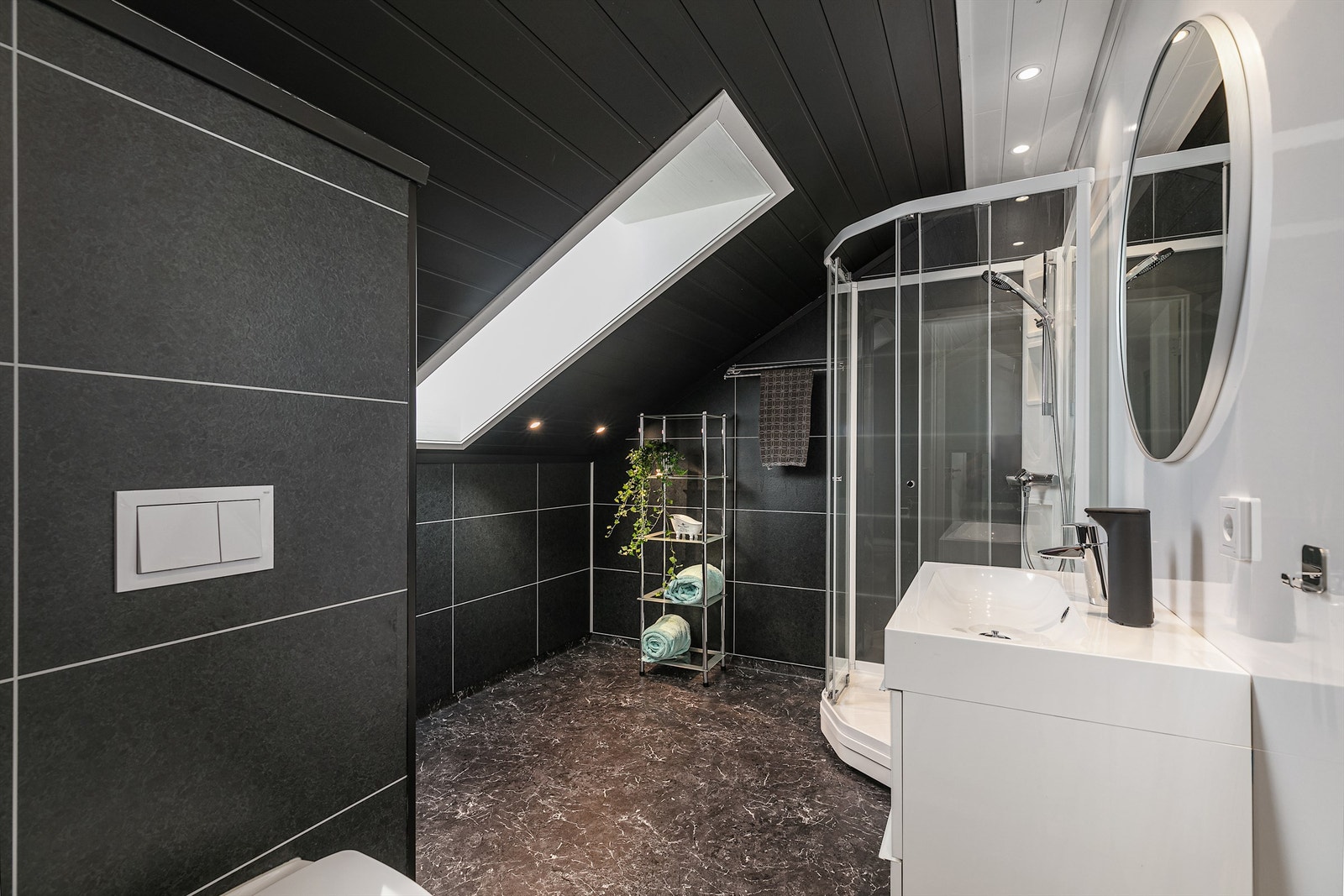 Flott bad i 2. etasje er laget i mørk utførsel wc, vask og dusj. Galleribilde
