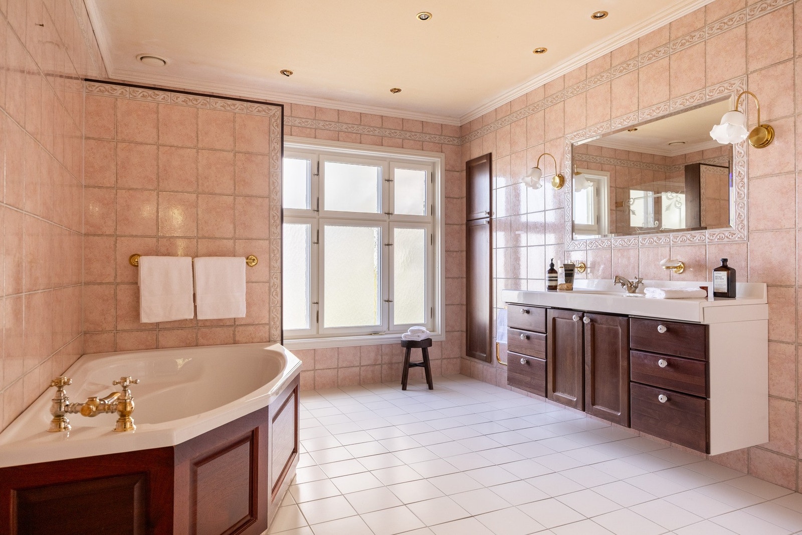 Stort baderom med flislagt gulv med varmekabler, badekar og stor dusjsone. Galleribilde