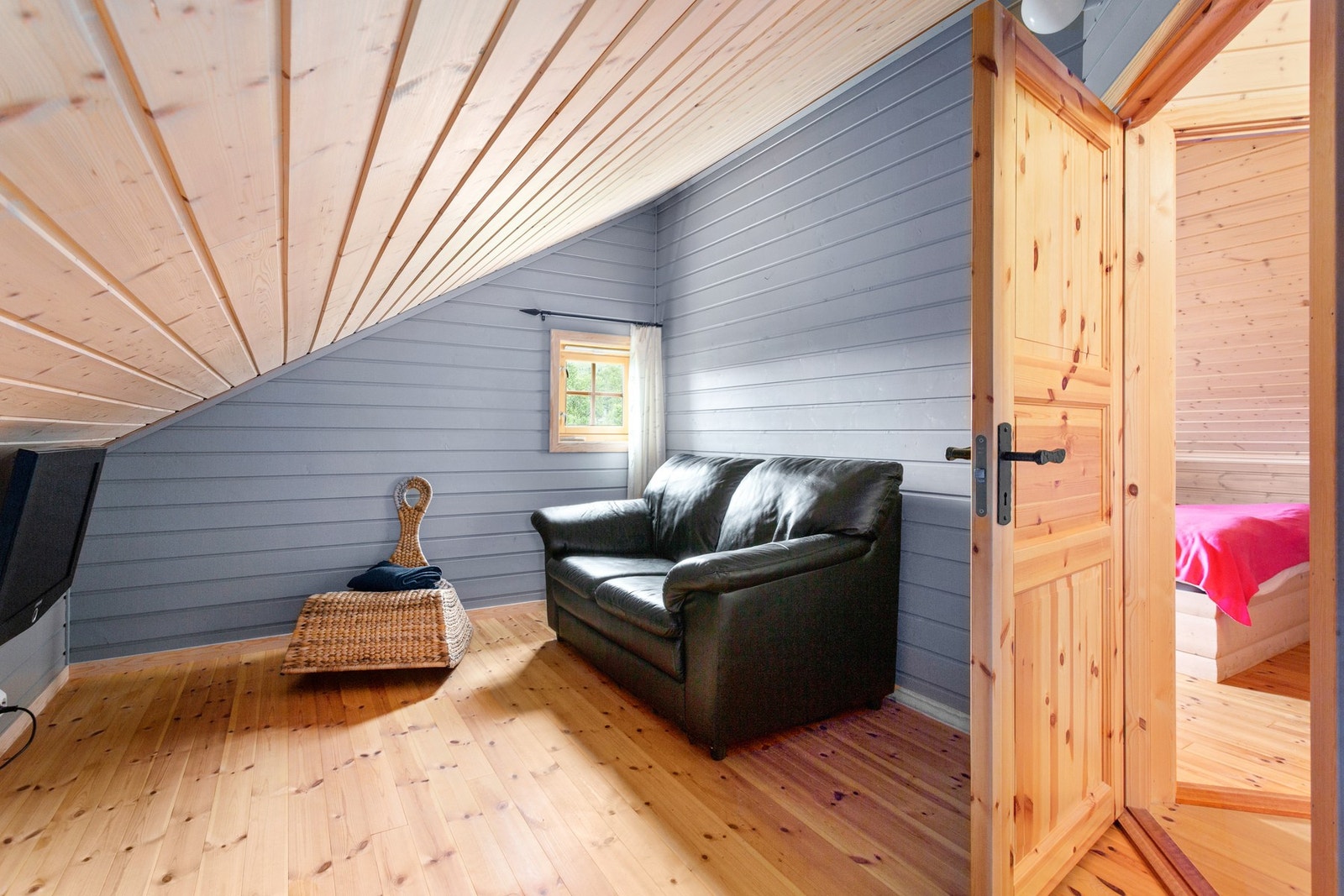 Innredet rom på loft med en liten tv-krok. Galleribilde