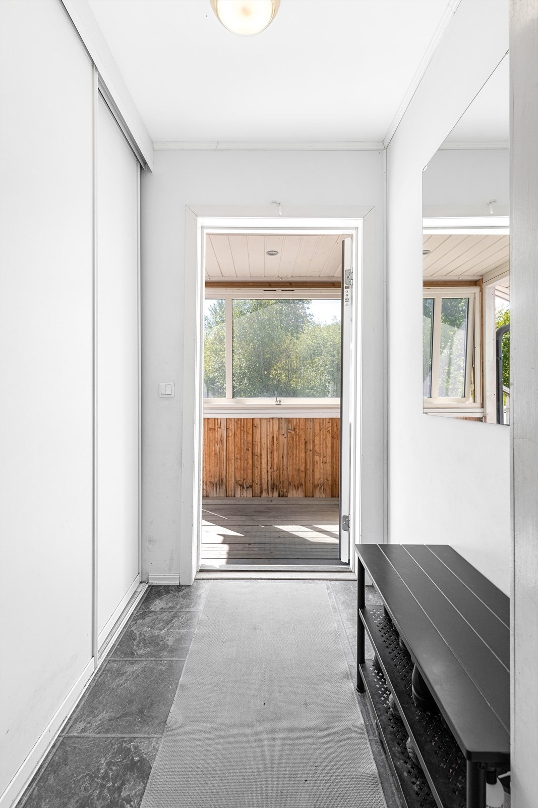 Flislagt entré, godt utstyrt med oppbevaringsmuligheter for yttertøy i integrert skyvedørsgarderobeskap. Galleribilde