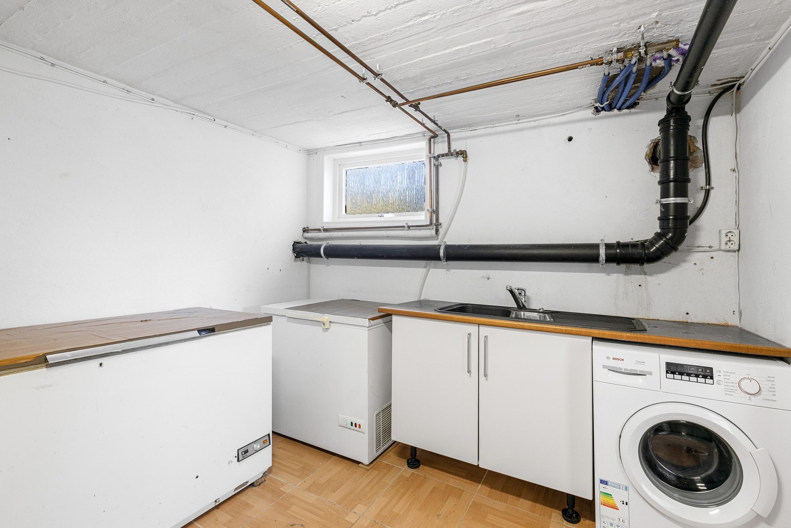 Vaskerom fra byggeår, sluk av typen støpejern. Rommet har flislagt gulv og malte overflater på vegger. Galleribilde