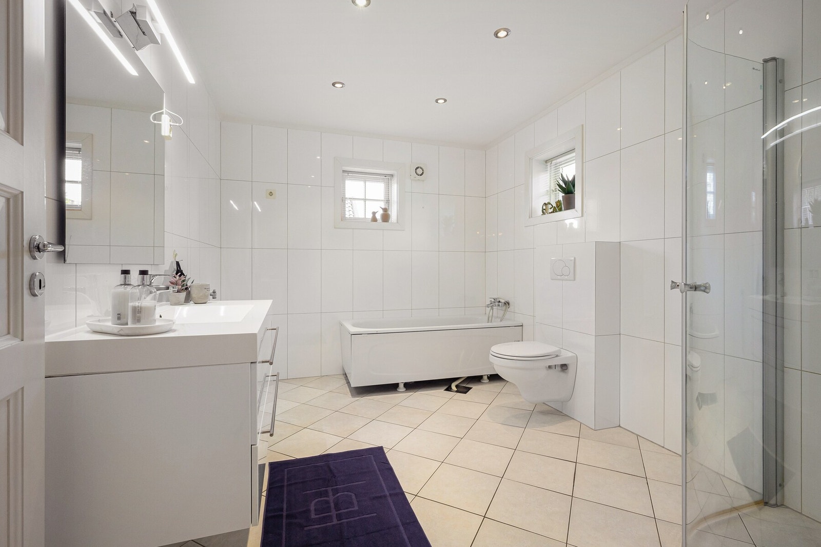 Lyst og romslig baderom med både dusj og badekar. Her foreligger det løsning for vaskemaskin og tørketrommel. Galleribilde