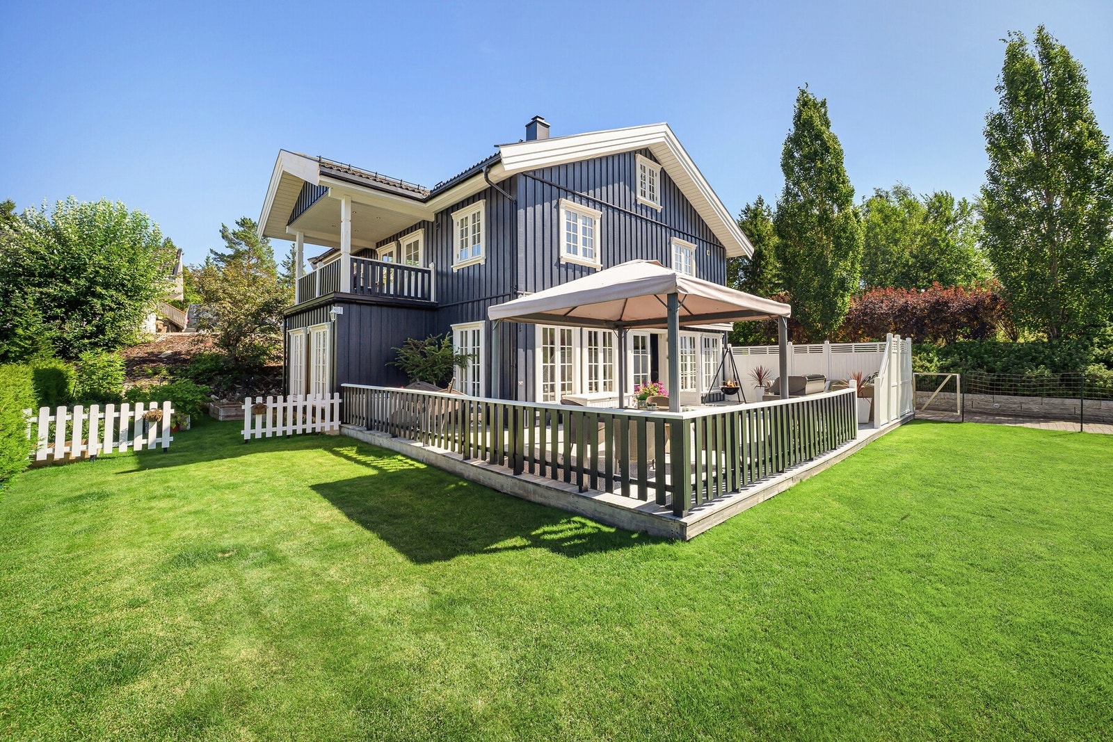 En praktfull eiendom med dobbel garasje, stor hage og steinbelagt gårdsplass. Galleribilde