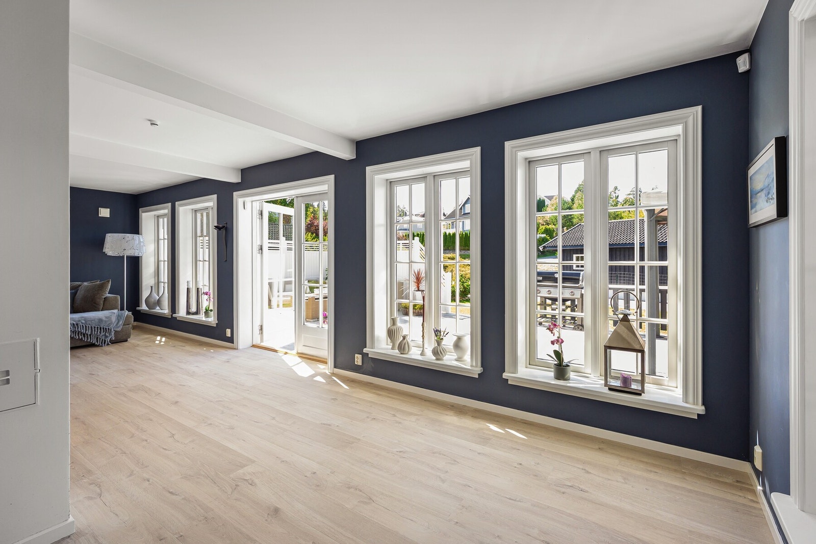 Stuen har store vindusflater og direkte utgang til terrasse som gir en sømløs overgang mellom inne- og uteareal. Galleribilde