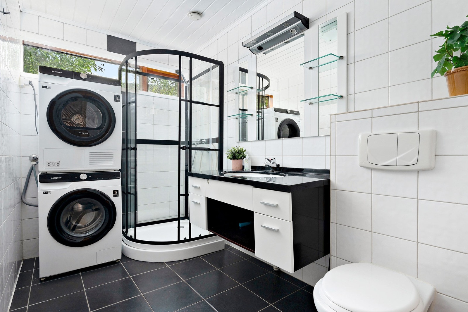 Badet ble pusset opp i 2006 og fremstår lyst og pent med fliser på både gulv og vegger. Badet er innredet med vegghengt toalett, dusjkabinett, servant med skap og opplegg for vaskemaskin. Galleribilde