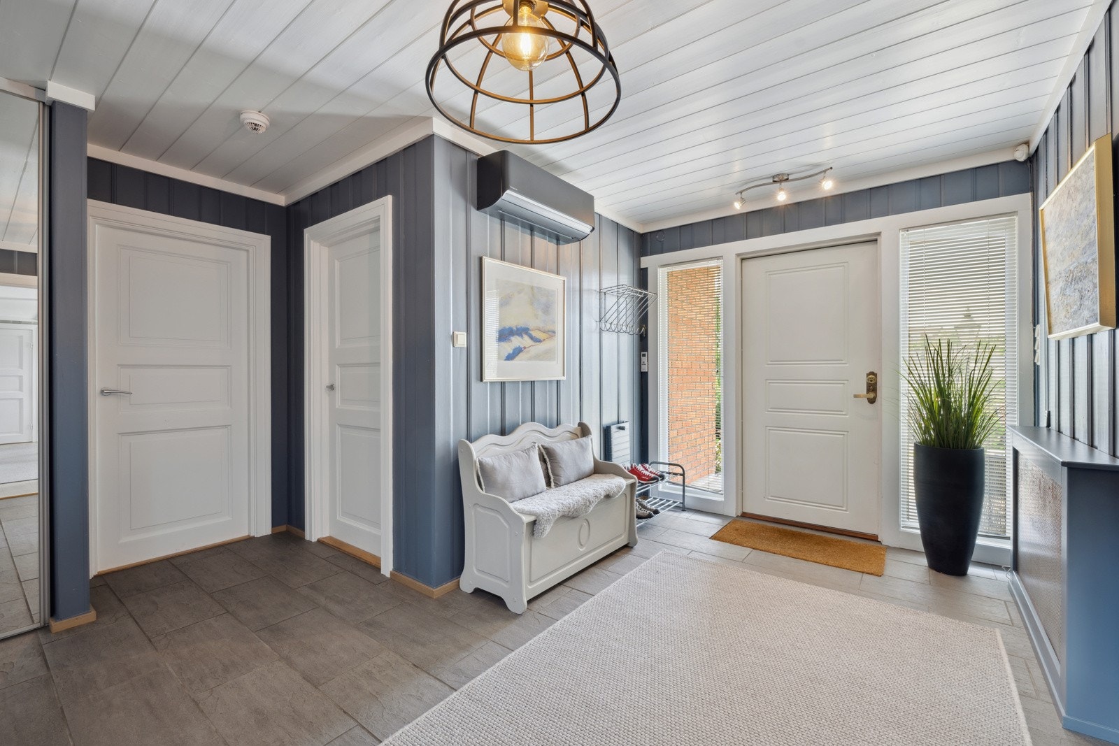 Hallen er dekket av gulvfliser med underliggende varme og det er skyvedørsgadrerobe ved siden av trappen. Galleribilde