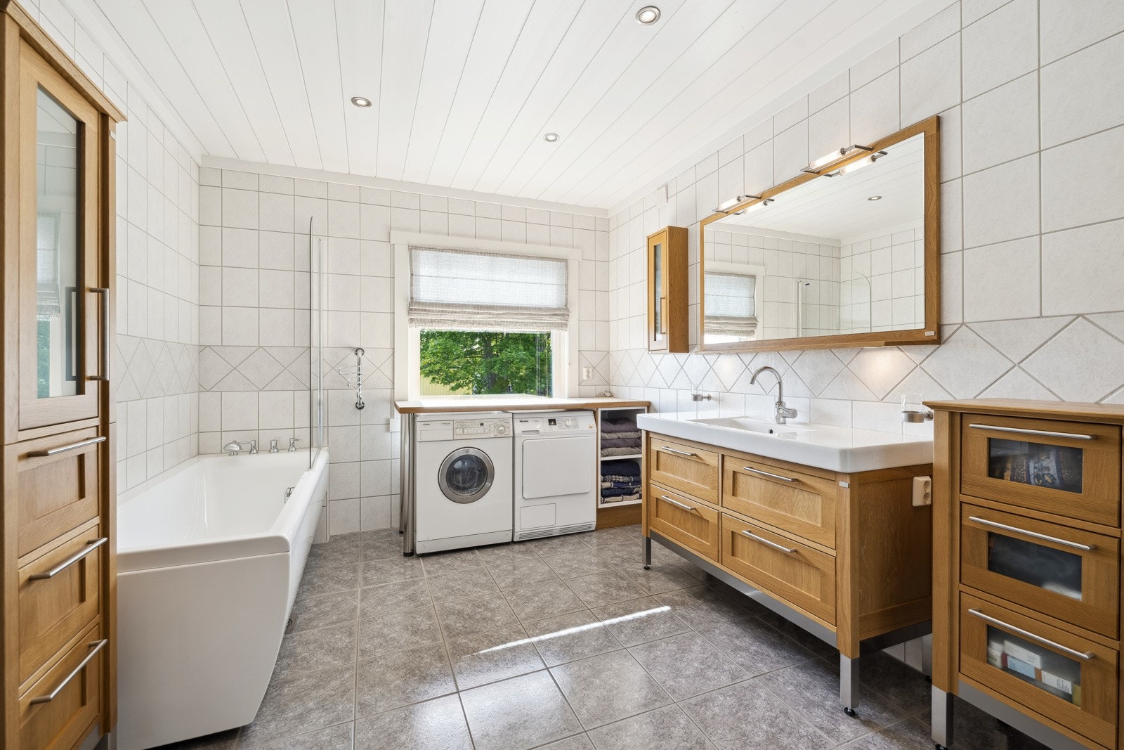 Flislagt baderom med varme i gulvet, dusj og badekar. Galleribilde