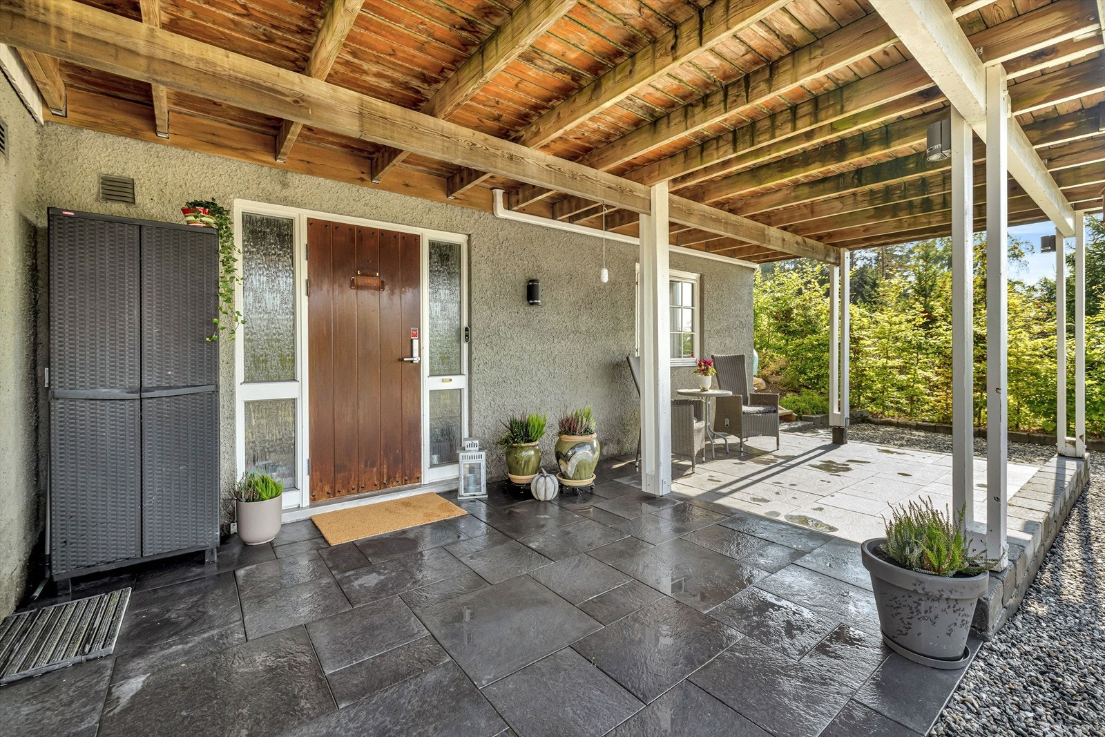 Inngangspartiet er overbygget og flislagt, noe som gir et pent og praktisk førsteinntrykk. Galleribilde